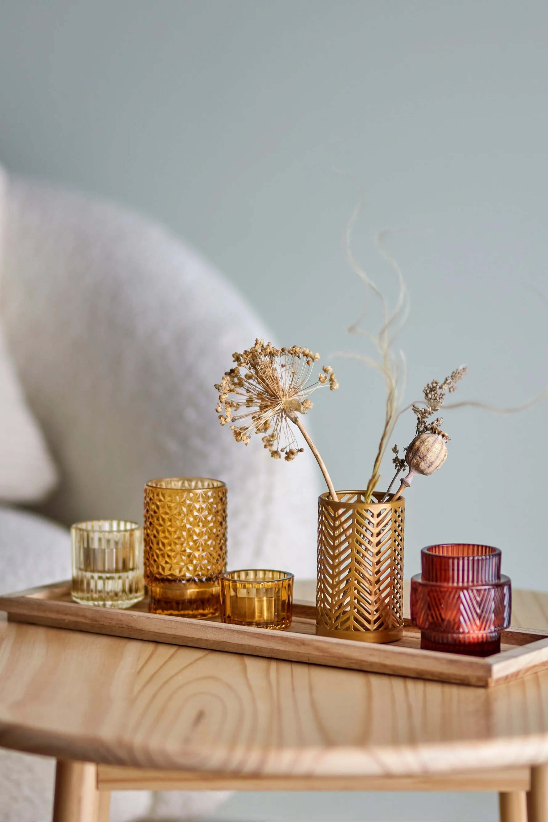 Täydellinen boho-sisustus: Bloomingvillen Sanga-tarjotin, jossa on keltaisen ja punaisen sävyisiä tuulivaloja, olohuoneen pöydällä.