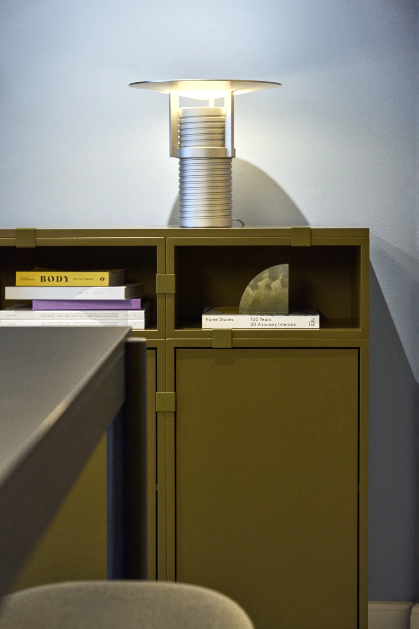 Vihreä hylly, joka on rakennettu Stacked-mallistosta, ja sen päällä hopeinen Set-pöytävalaisin, kaikki Muutolta.