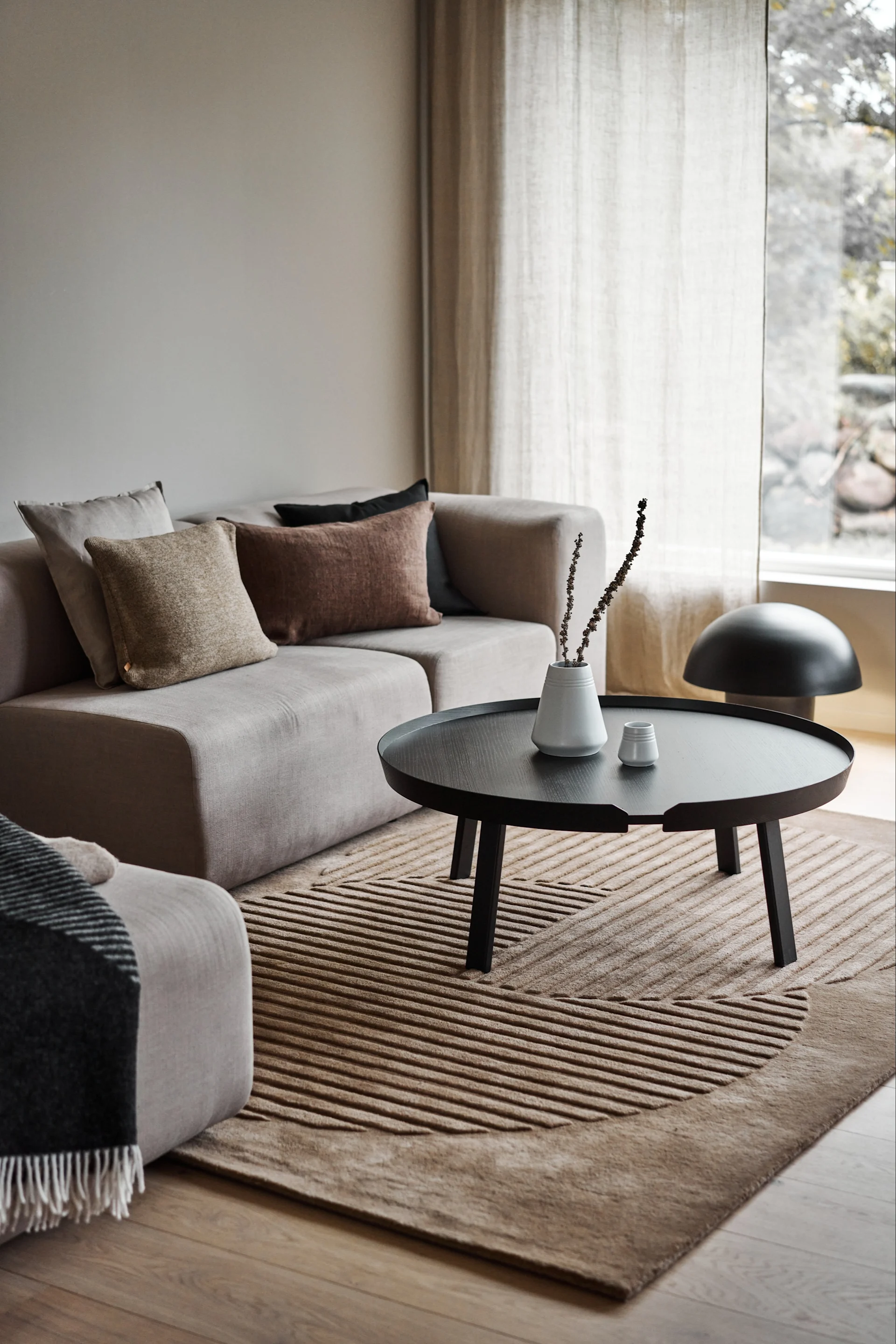 Sisusta olohuone viihtyisillä matoilla - tässä näet NJRD:n beige Circles -villamatto beigessä olohuoneessa.