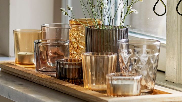 Täydellinen boho-sisustus: Bloomingvillen Sanga-tarjotin, jossa on eri kelta- ja ruskeasävyisiä teekynttilänjalkoja, seisoo ikkunalaudalla.