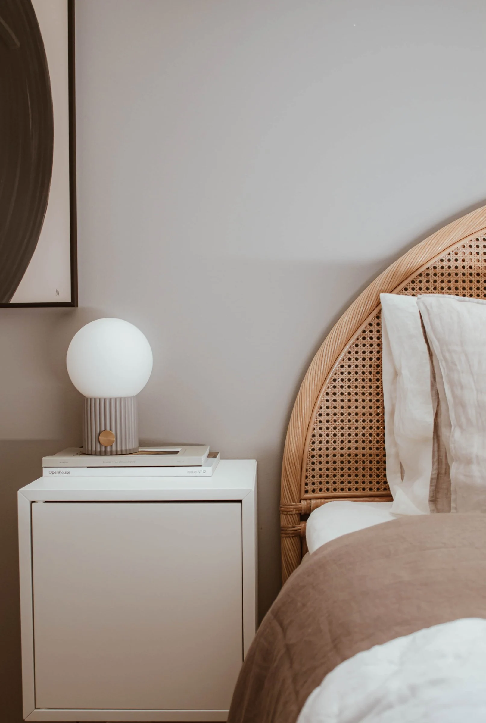 Harmaa Hubble-pöytävalaisin seisoo boho-tyylisen makuuhuoneen yöpöydällä.