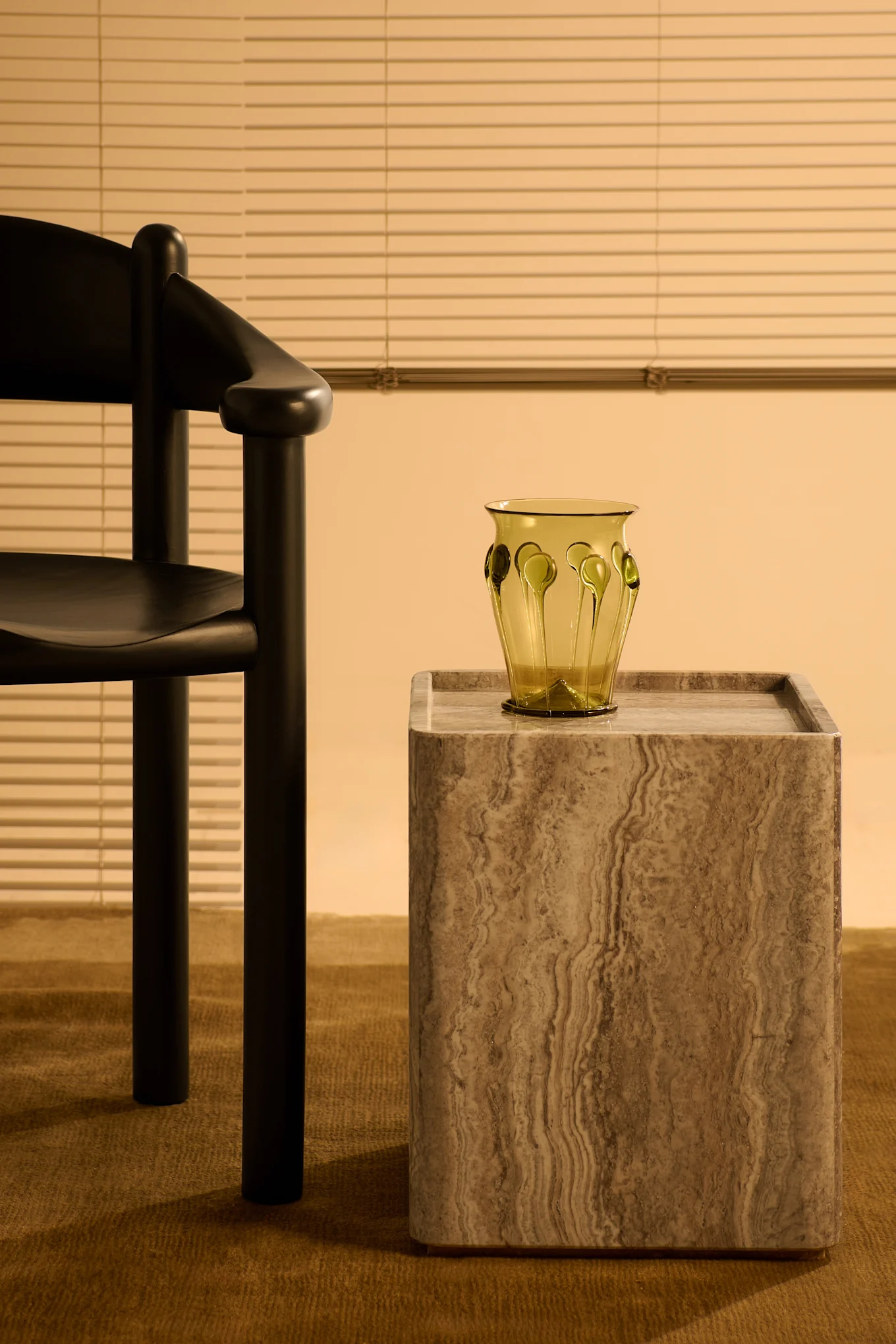 Gubin travertiinista valmistettu sivupöytä ja Gubin mustasta männystä valmistettu tuoli, jotka sopivat sisustustrendeihin 2025. 