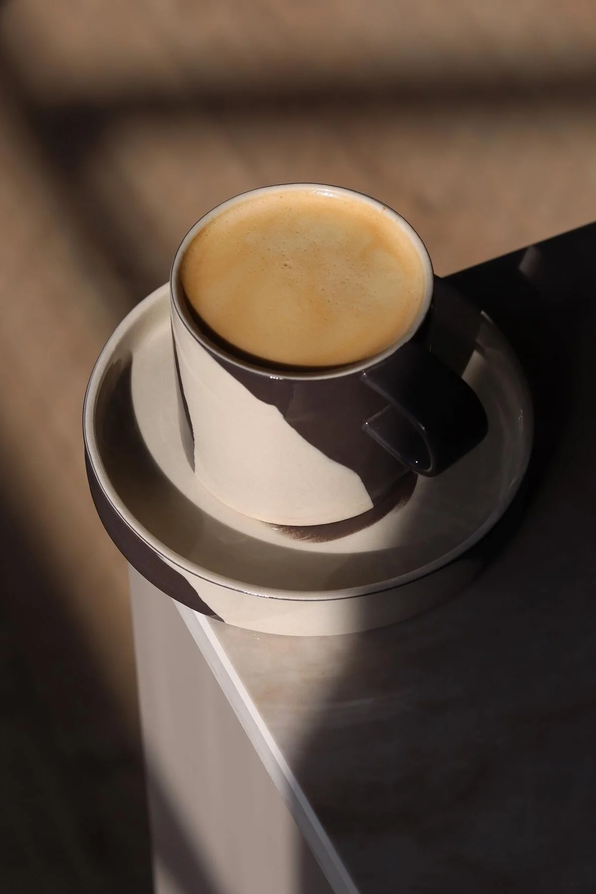 Ferm Livingin mustavalkoinen kuviollinen inlay-muki seisoo @saraelineeriksenin kodin pöydän kulmassa.