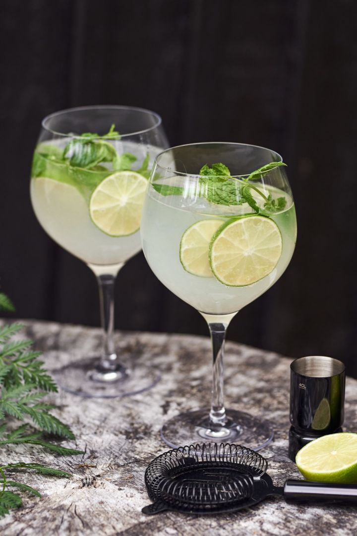 Gin-tonic-tyyppinen cocktaillasi, jossa on cocktail ja lime. 