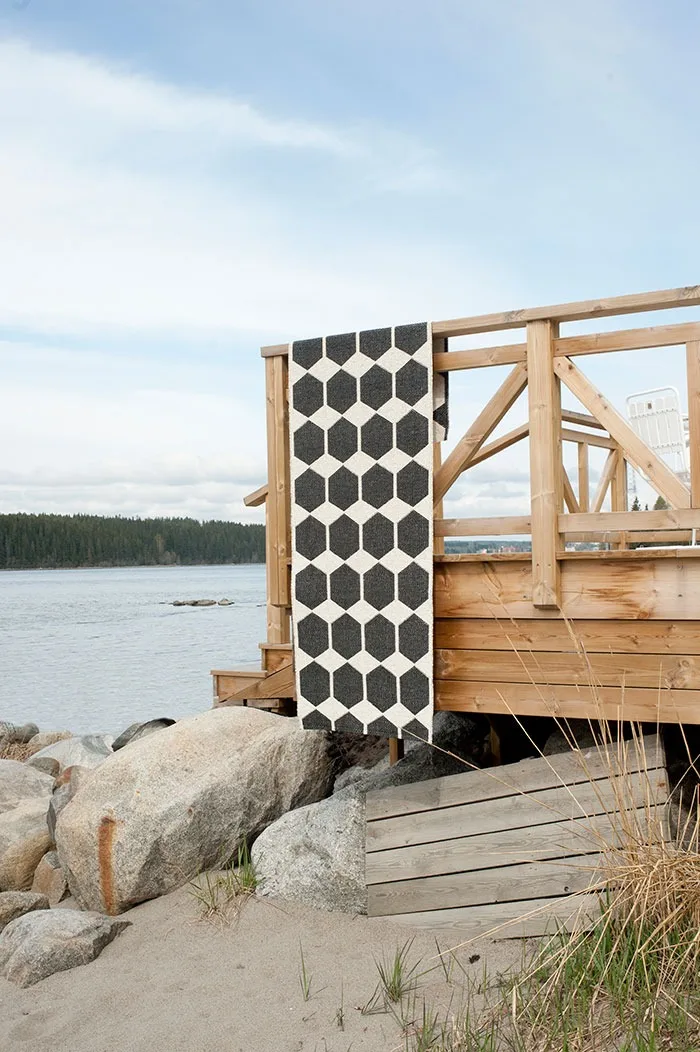 Ulkomatto: Puhdista ulkolattiamatto säännöllisin väliajoin ja ripusta kuvassa näkyvä Brita Swedenin musta Anna-matto esimerkiksi parvekekaiteen päälle kuivumaan.