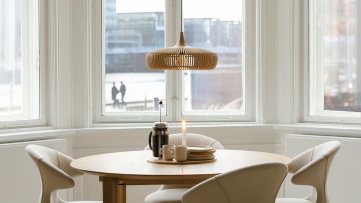 Lagom: Minimalistisesti sisustettu ruokasali, jossa on paljon ikkunoita ja Umagen Clava Dine Wood -riippuvalaisin.