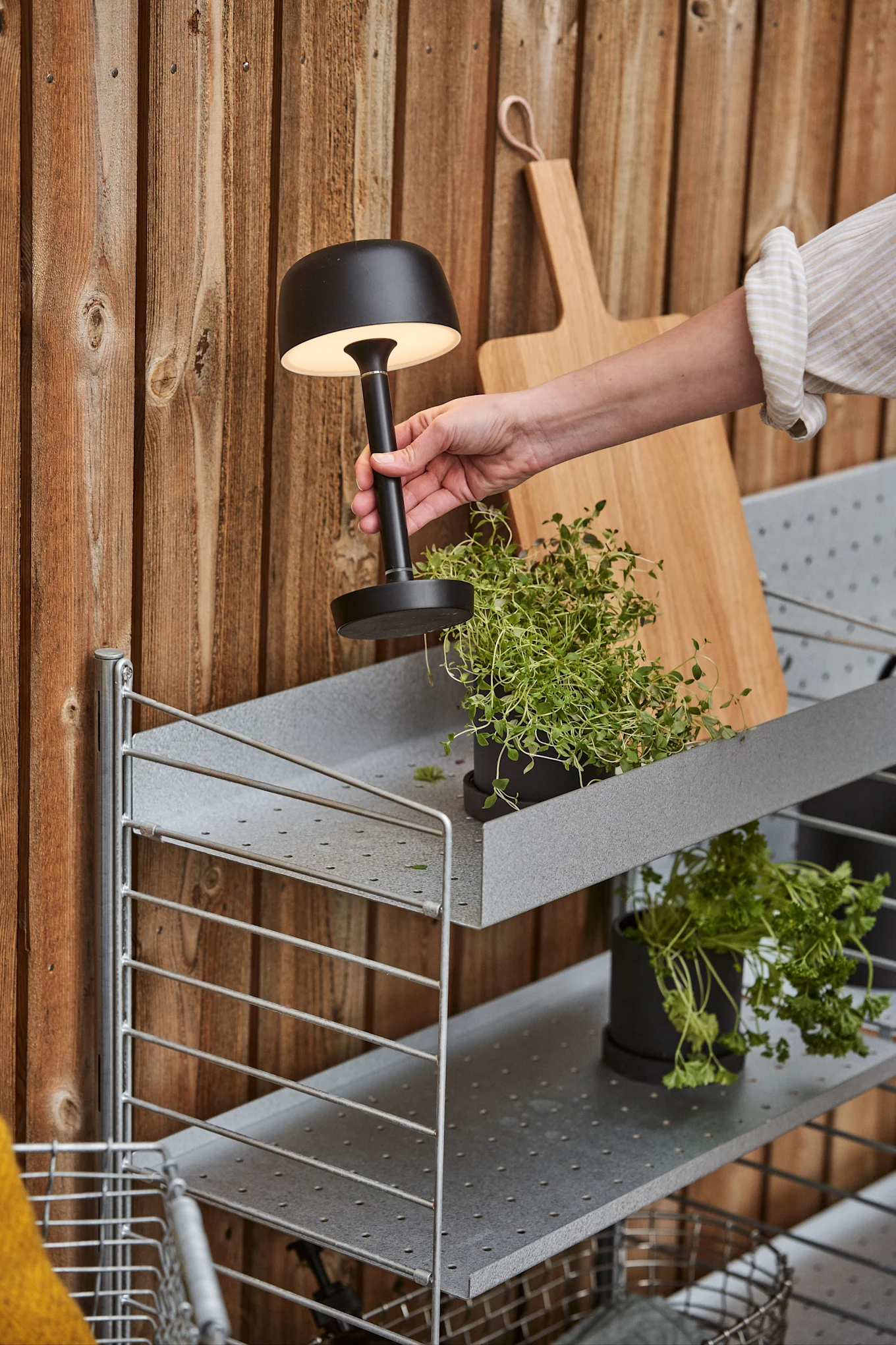 Scandi Livingin musta Halo-latauslamppu sijoitetaan ulos hyllylle.