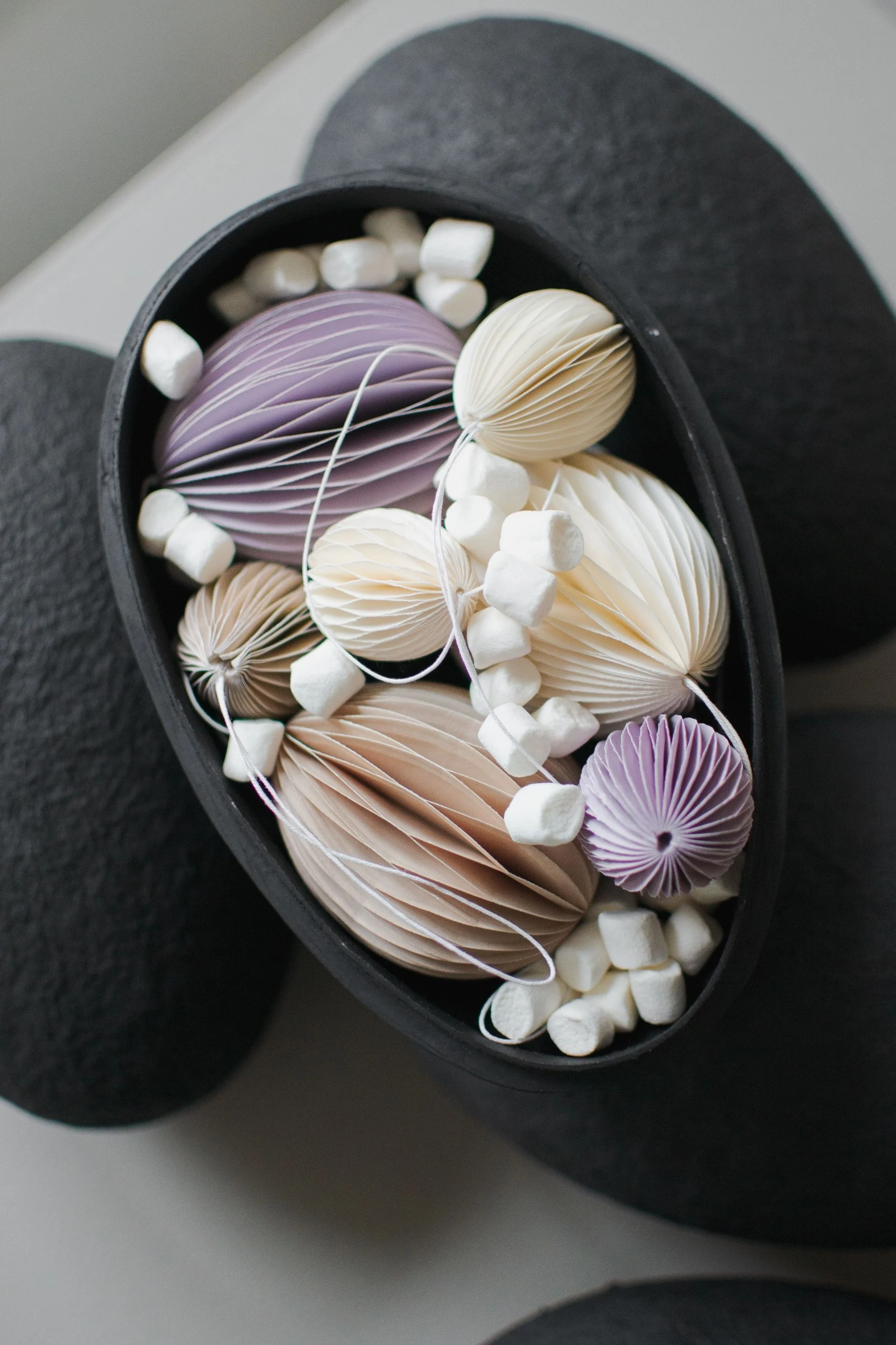 Pääsiäiskoriste: Tässä näet dbkd:n eri värisiä ovaalipaperisia pääsiäistunnisteita kulhossa.