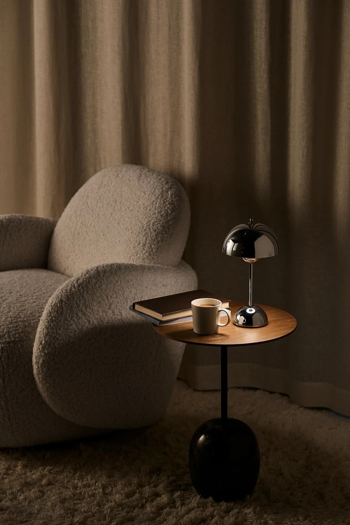 Vuoden 1898 Mo-tuolin vieressä on sohvapöytä, jolla on kirja, kahvikuppi ja &Traditionin kromivärinen Flowerpot-pöytävalaisin.