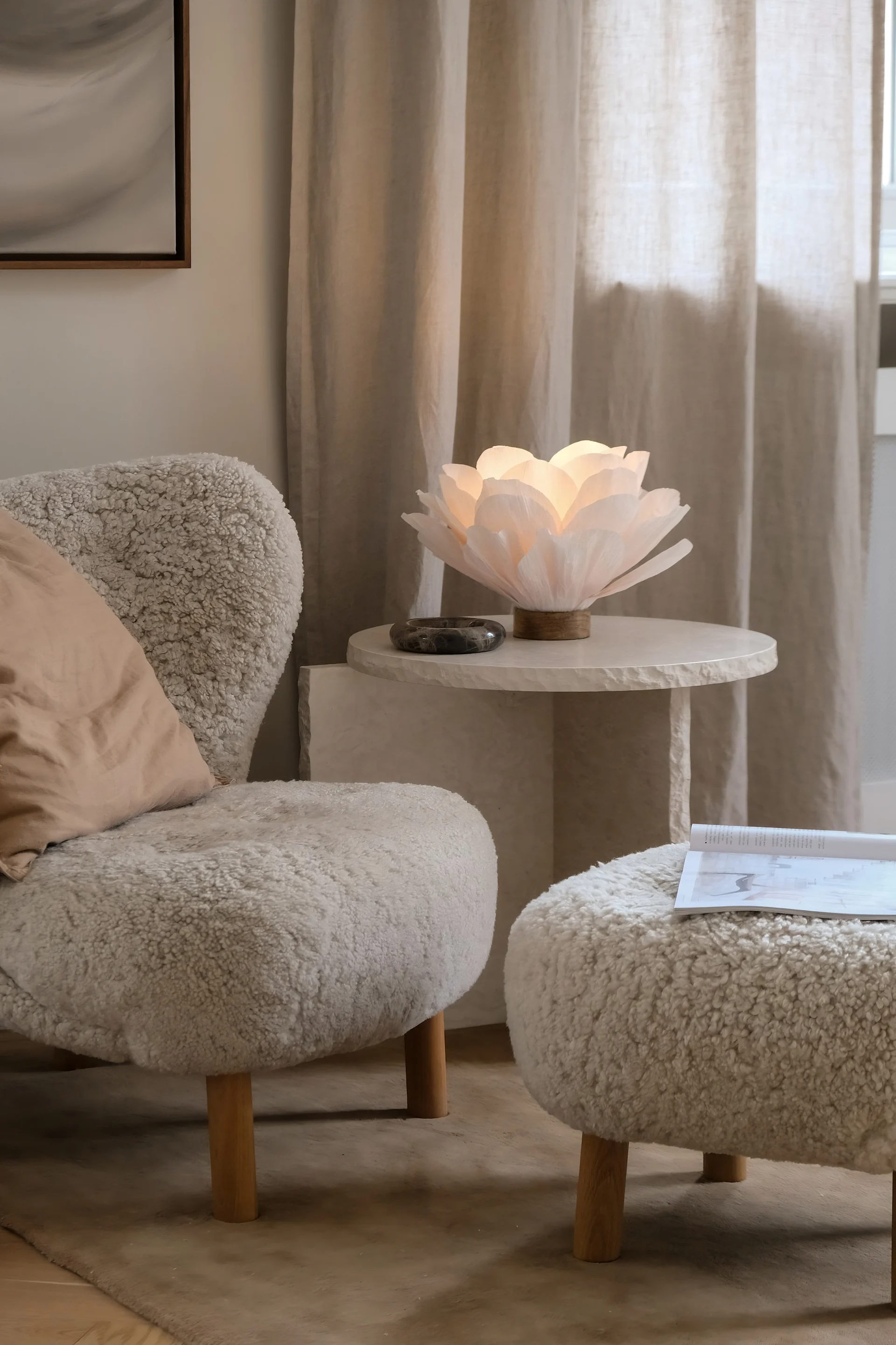 Beigenvärinen olohuone, jossa on Little Petra -nojatuoli ja marmorinen sohvapöytä, koristeltu Watt & Veken Lisa-pöytävalaisimella.