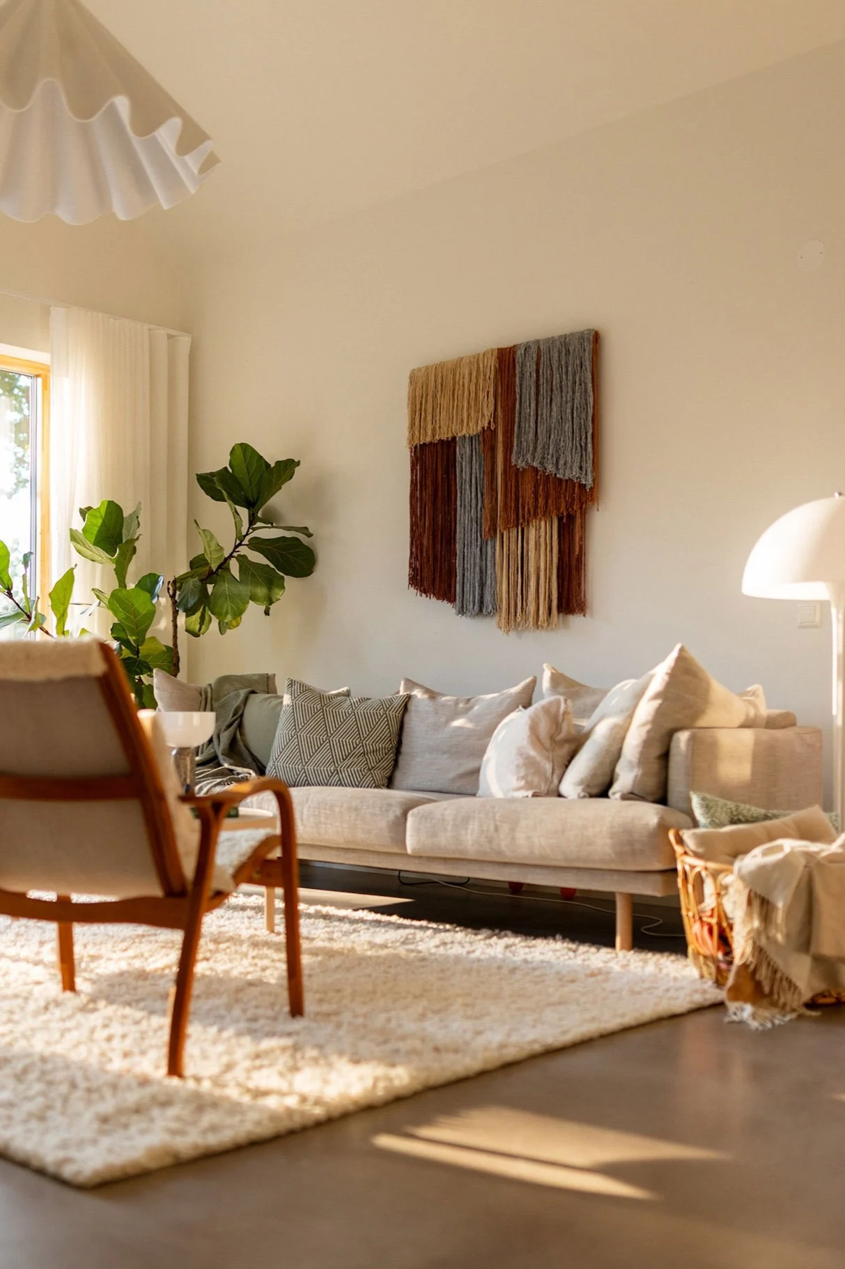 Tintedin Tham-seinätekstiilikoriste roikkuu olohuoneen seinällä sohvan yläpuolella.