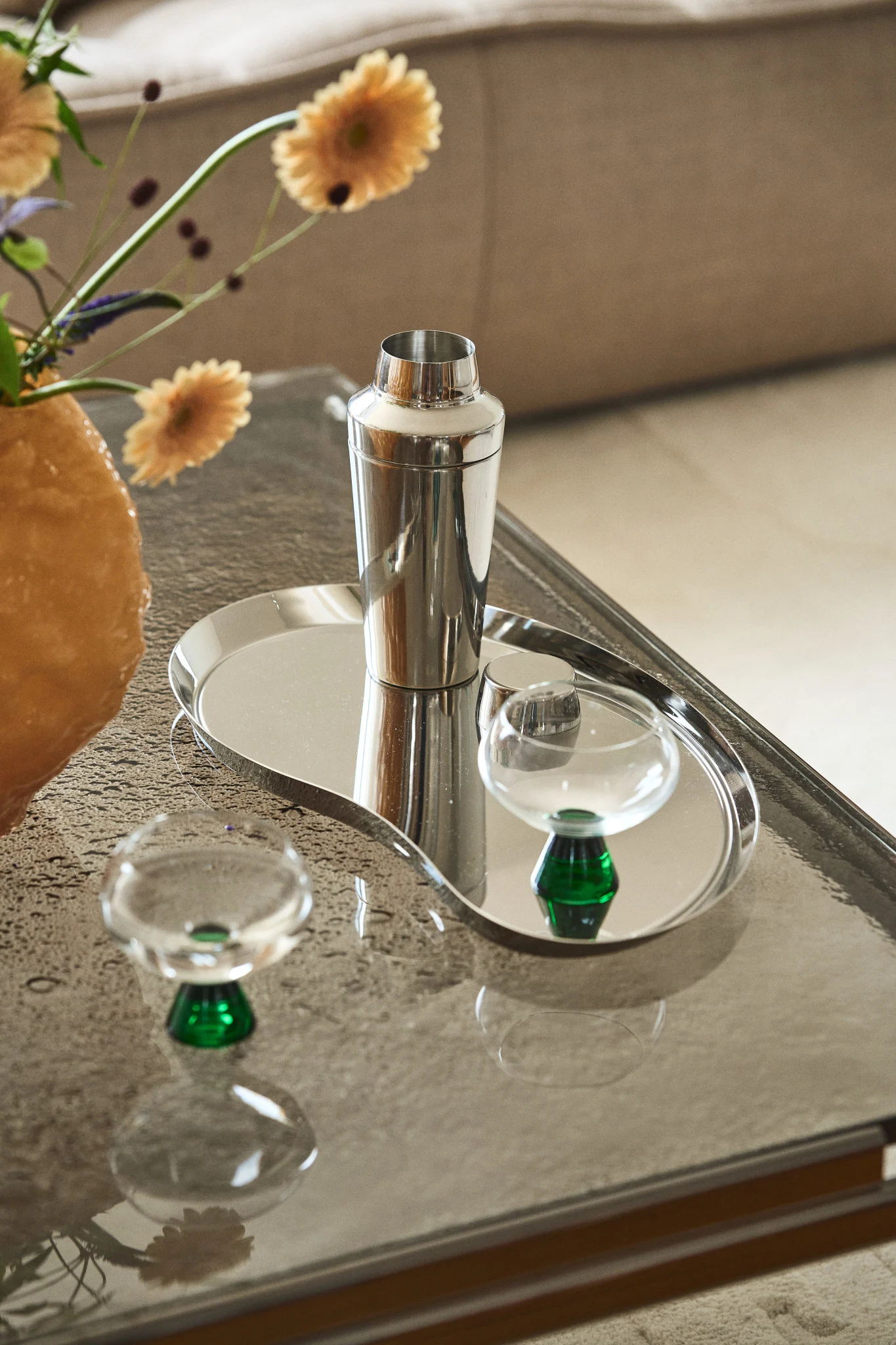 Lahjoita cocktail-setti tai kauniit lasit ystävänpäivänä. Tässä Rosendahlin Grand Cru -shaker on kromivärisellä tarjottimella sohvapöydällä, sen vieressä Byonin Indy-lasit.