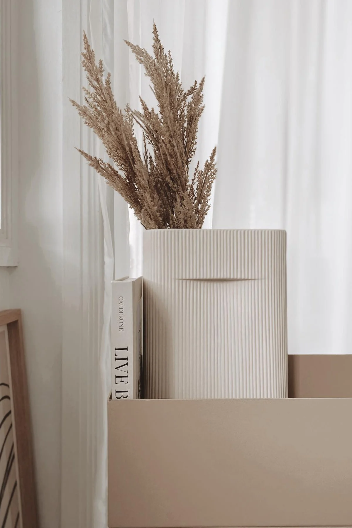 Lagom-tyylinen sisustus tarkoittaa myös hillittyjä värejä. Ferm Livingin beige Plant box -kasvilaatikossa on Muuton Ridge-maljakko, jossa on kuivakukkia @beige_and_co:n kodissa.