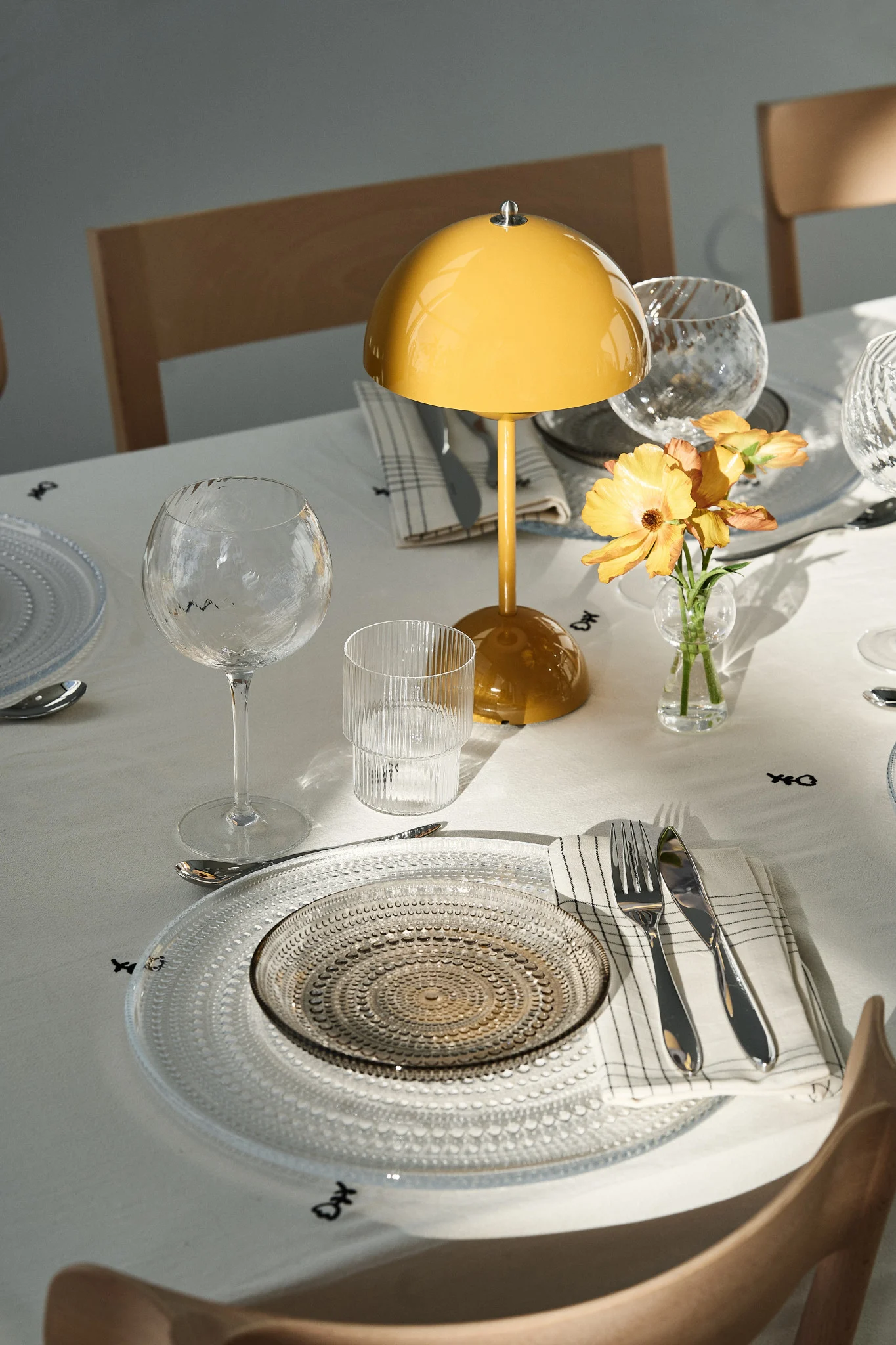 Katettu pöytä on tärkeä osa jokaista juhlaa. Tässä näet juhlapöydän, jossa on kannettava Flowerpot-lamppu ja juhlavat lasilautaset. 