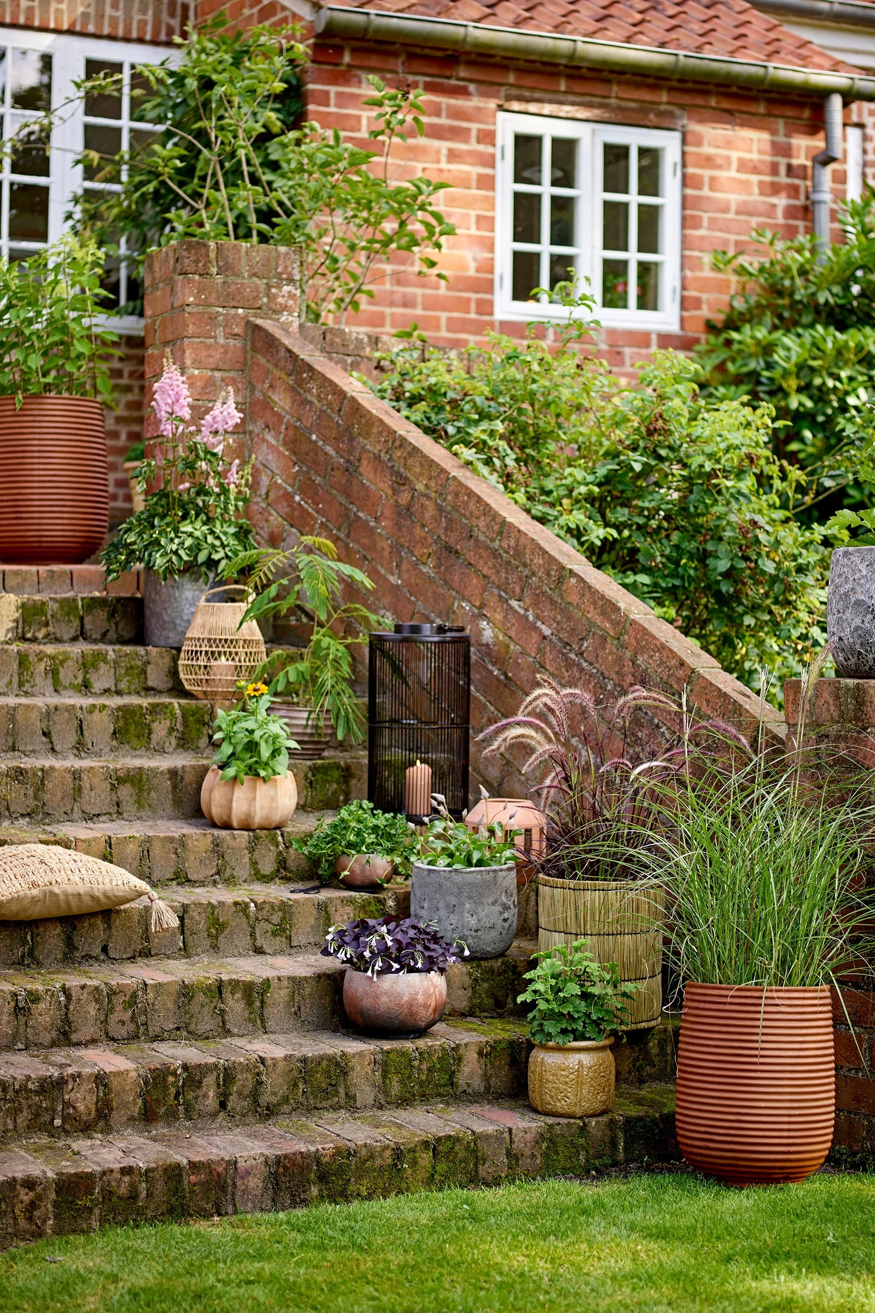 Puutarhan portailla on erilaisia boho-tyylisiä kukkaruukkuja, joissa on kasveja, muun muassa Bloomingvillen Mesola-kukkaruukku.