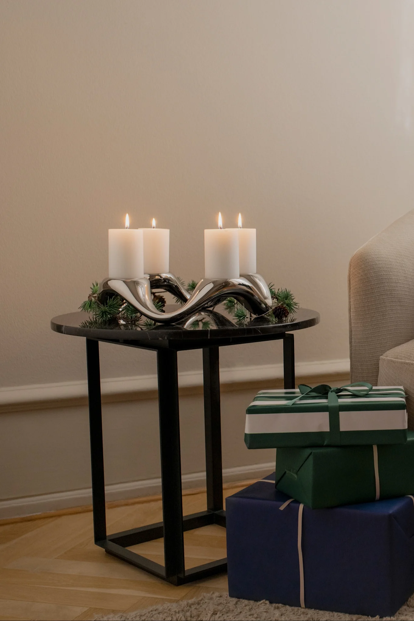 Sivupöydällä on Georg Jensenin Cobra-kynttilänjalka, joka on koristeltu kuusenoksilla.