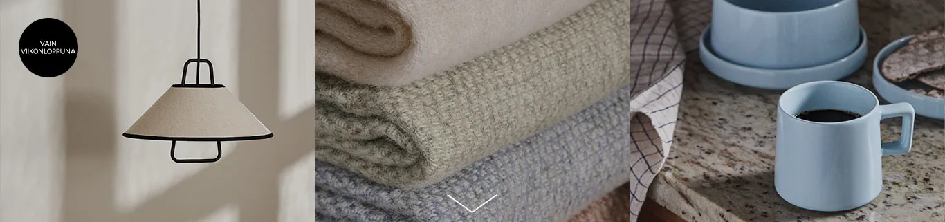 Moderni riippuvalaisin, pino vaaleita peittoja ja kahvia sinisessä mukissa. Musta ympyrä, jossa valkoinen teksti: VAIN VIIKONLOPPUNA.