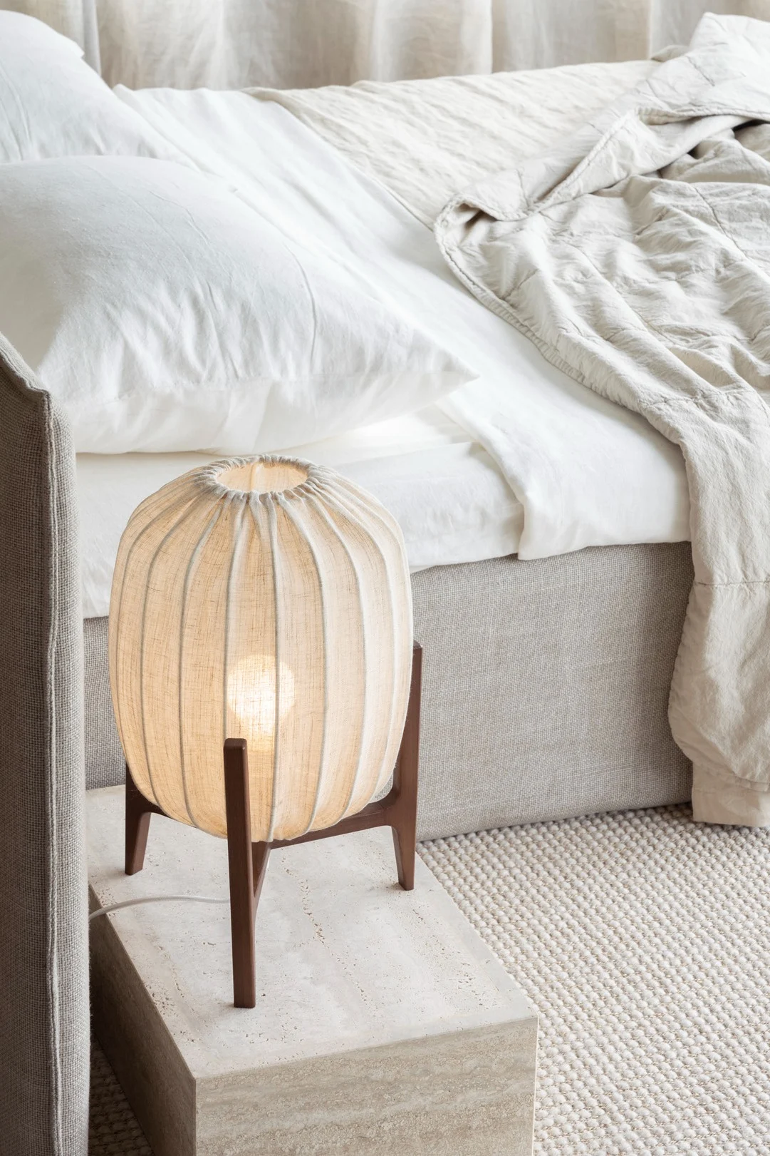 Luonnonmateriaaleista, kuten kankaasta ja puusta valmistetut huonekalut ja asusteet sopivat täydellisesti lagom-tyyliseen sisustukseen. Kuvassa Watt & Veken Prisma-pöytävalaisin seisoo sängyn vieressä.