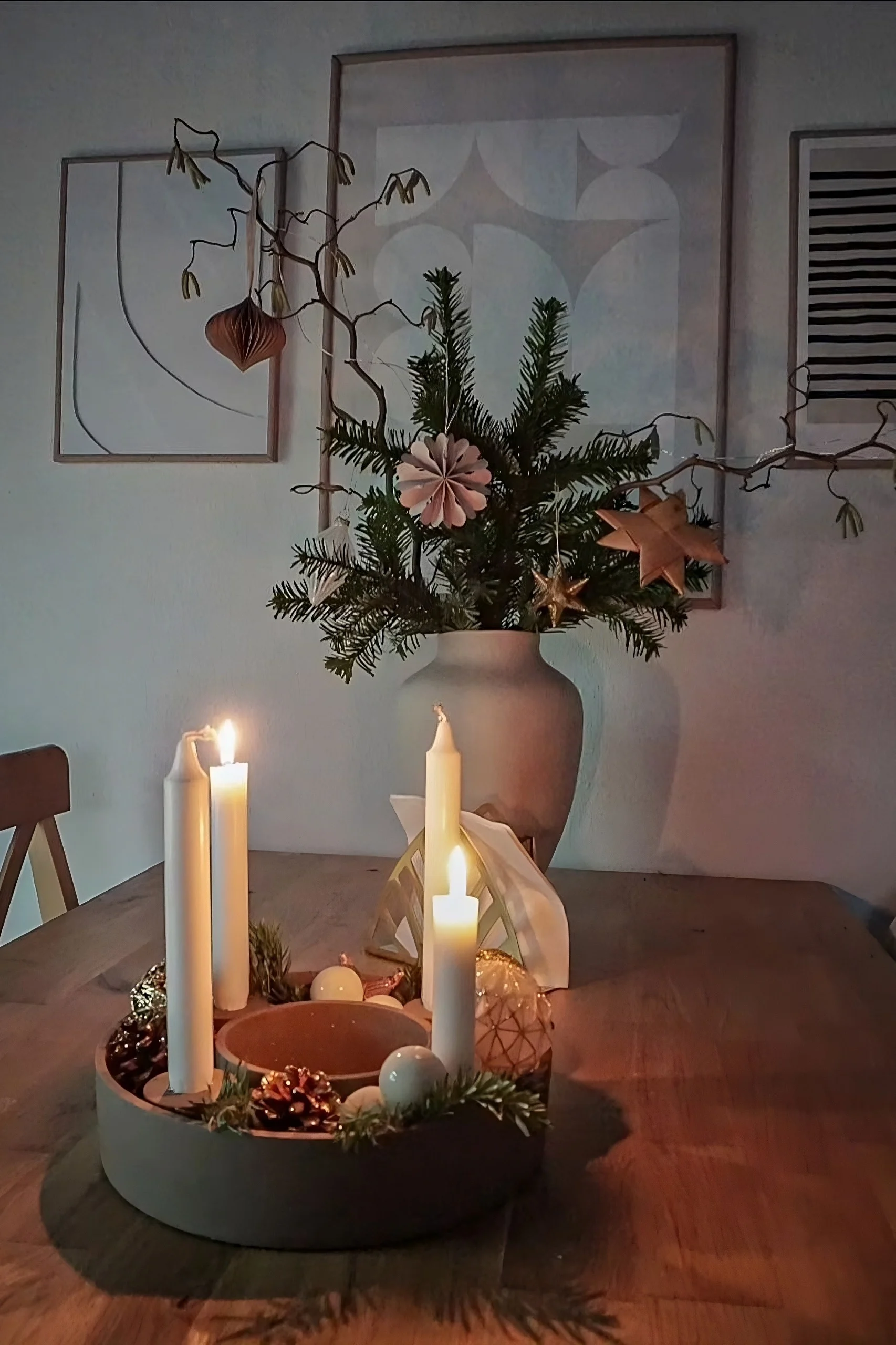 Puisella pöydällä seisoo House Doctorin The Ring -kynttilänjalka, joka on koristeltu käpyillä ja kuusenoksilla.