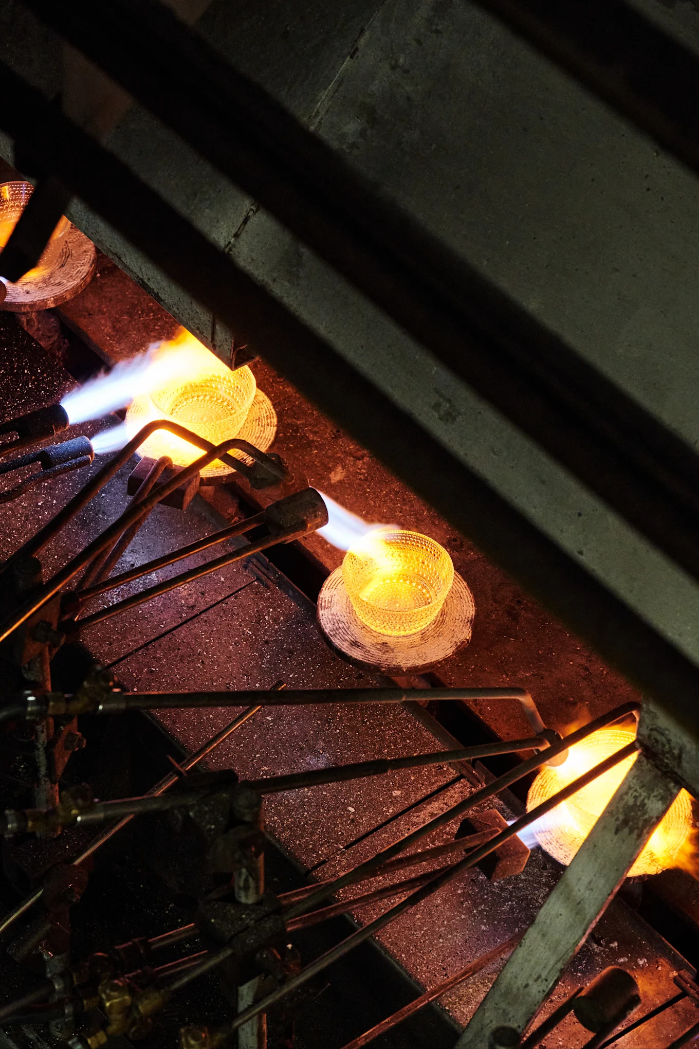 Kastehelmi-kulho lämmitetään tuotantolinjalla Iittalan lasitehtaalla Suomessa.