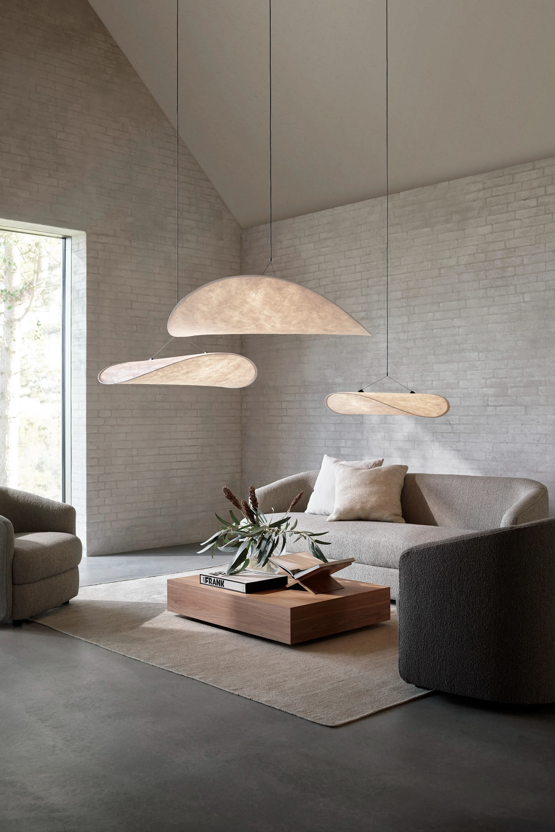 Suuri olohuone, jossa kolme Tense-riippuvalaisinta roikkuu ryhmänä sohvan yläpuolella.