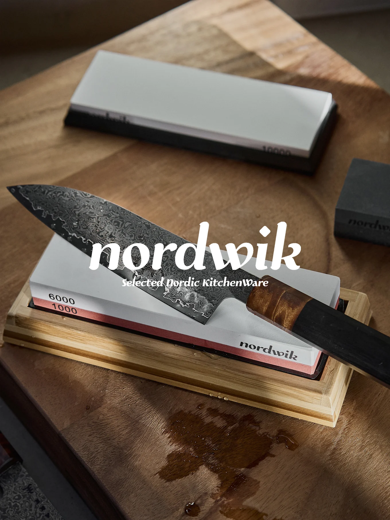 Damascus-kokinveitsi teroituskivellä, jossa 1000 ja 6000 karkeus, märällä puupinnalla.