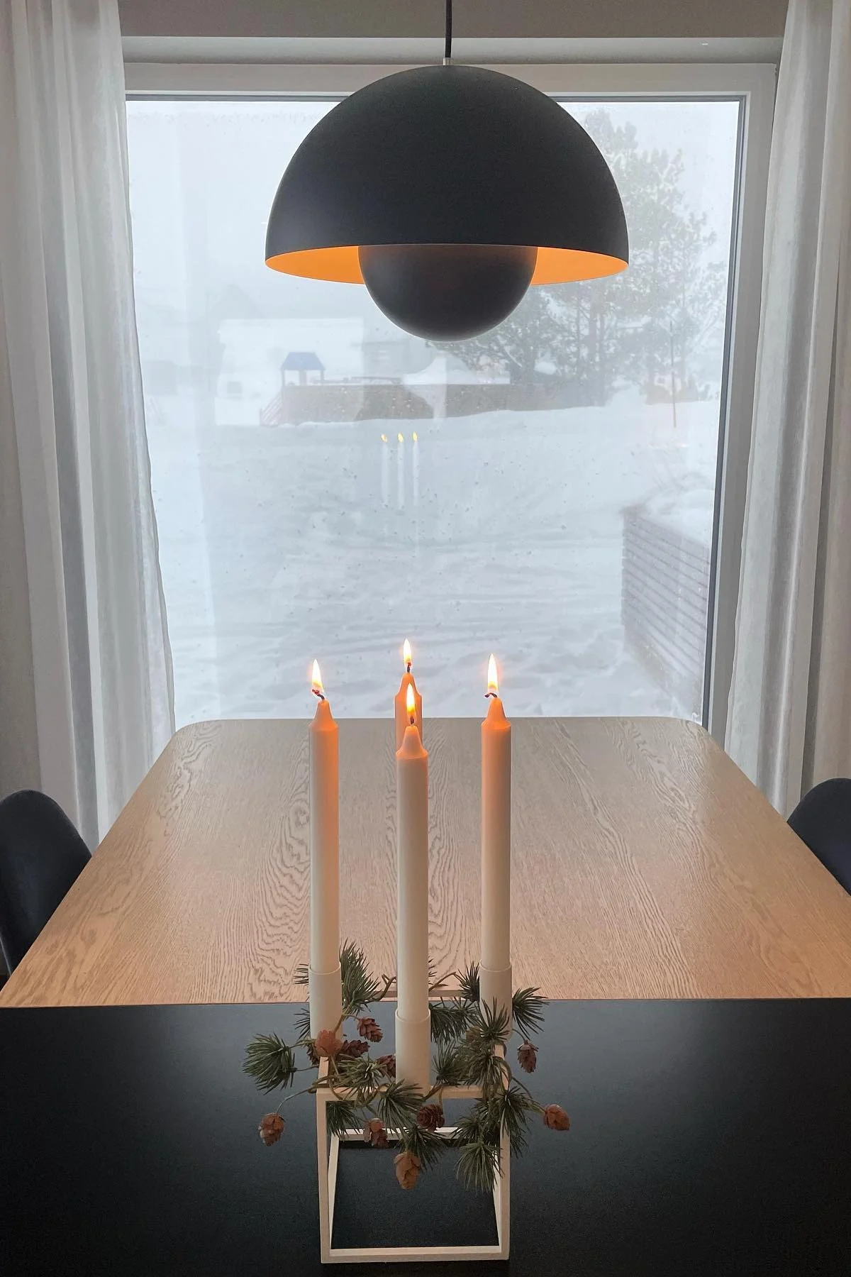 Yksinkertaisella ruokapöydällä seisoo Audo Copenhagenin minimalistisesti koristeltu Kubus-kynttilänjalka.