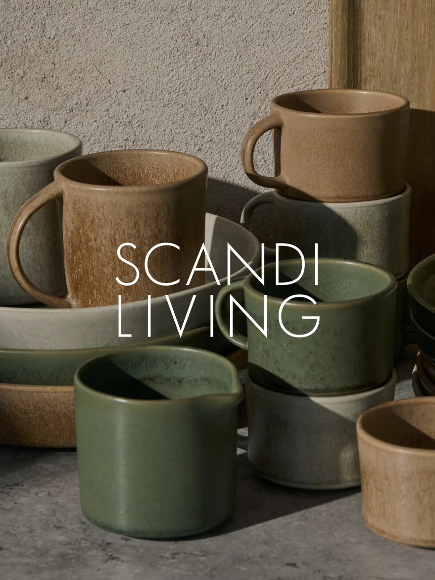 Kokoelma maanläheisiä keramiikkamukeja ja -astioita, osa pinottuna, tekstillä 'SCANDI LIVING'.