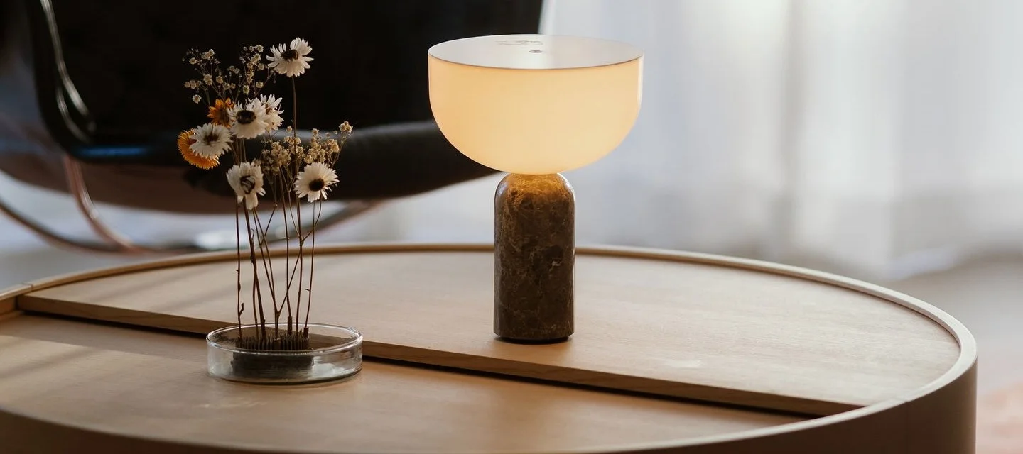 Woudin Arc-sohvapöytä on koristeltu New Worksin Kizu-pöytävalaisimella ja Garden Gloryn kukkakärpäsellä.