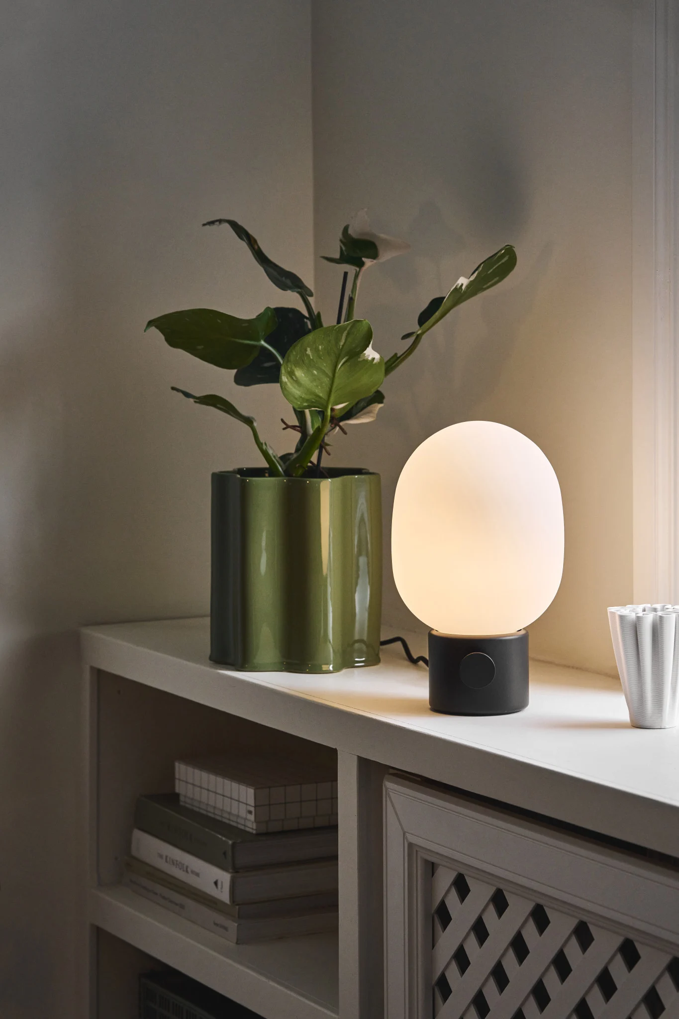 Skandinaaviset lamput: Audo Copenhagenin JWDA-pöytävalaisin seisoo ikkunalaudalla kukkaruukun vieressä.