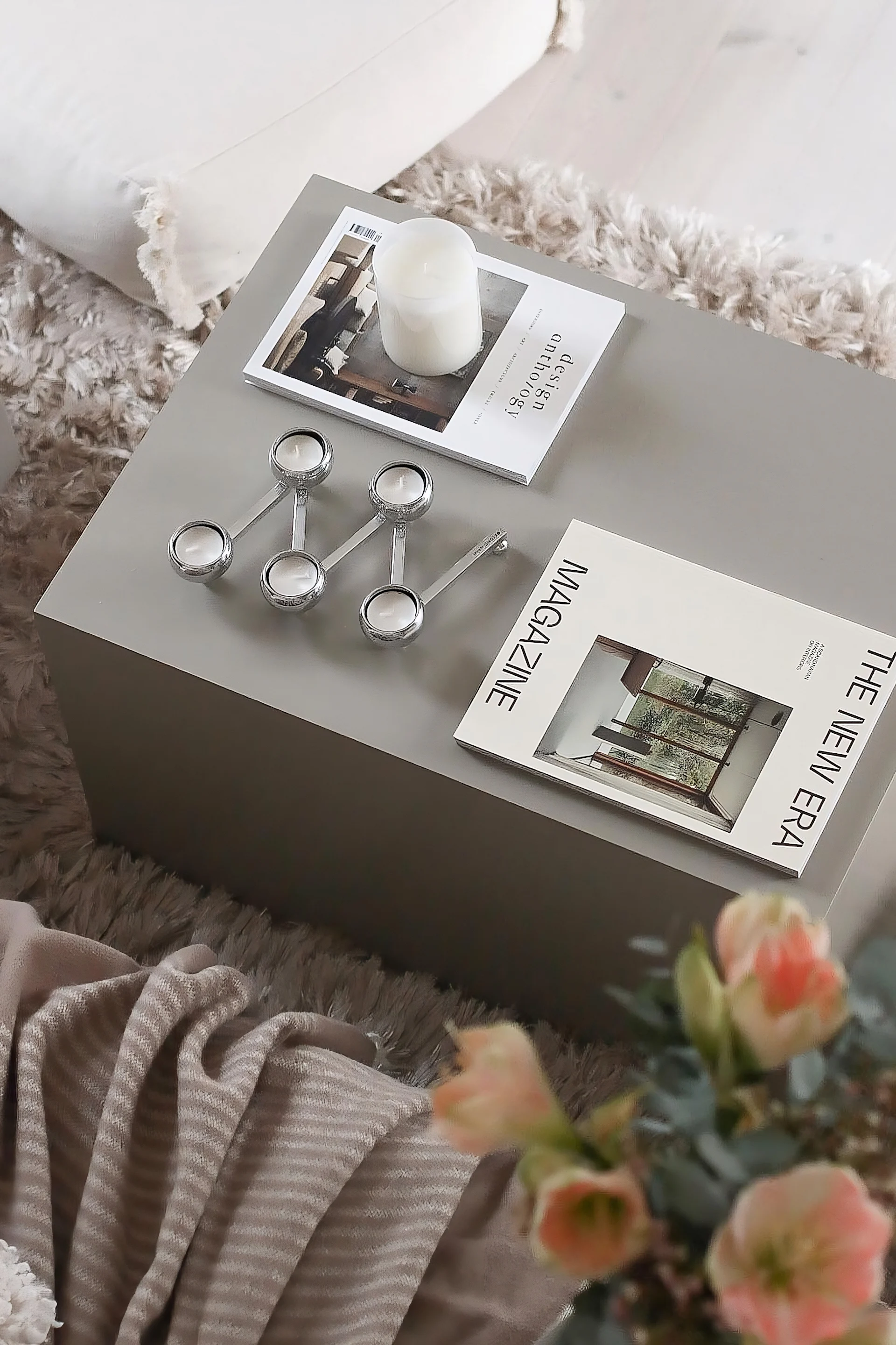 Suorakulmainen sohvapöytä, koristeltu lehdillä ja Klongin Constella-kynttilänjalalla.