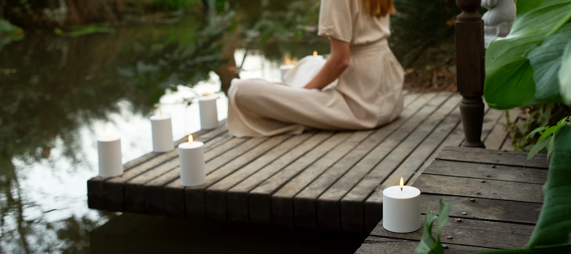 Lagom tarkoittaa myös rentoutumista. Tässä kuva näyttää naisen istumassa laiturilla, ympäröitynä Uyunin LED-kynttilöillä.