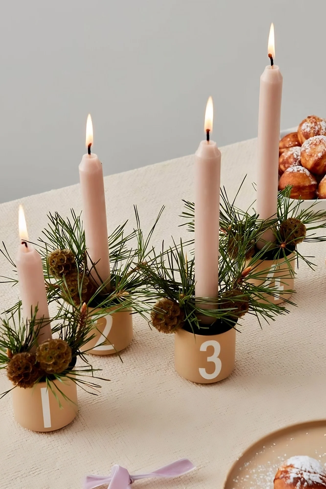 Pöydällä on neljä Design Lettersin espressokuppia, jotka on koristeltu jouluisiksi kynttilänjaloiksi.