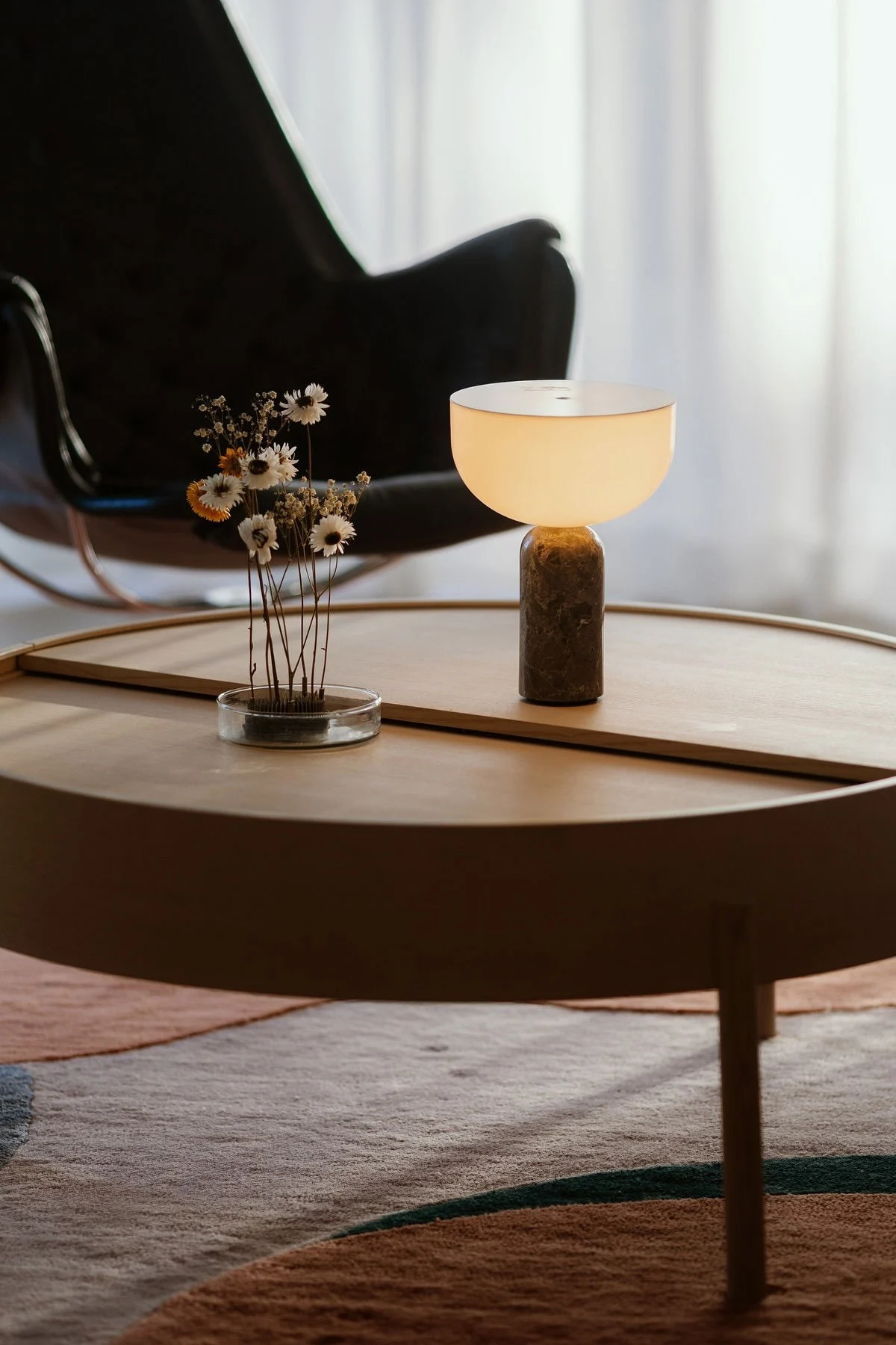 Woudin Arc-sohvapöytä on koristeltu New Worksin Kizu-pöytävalaisimella ja Garden Gloryn kukkakärpäsellä.