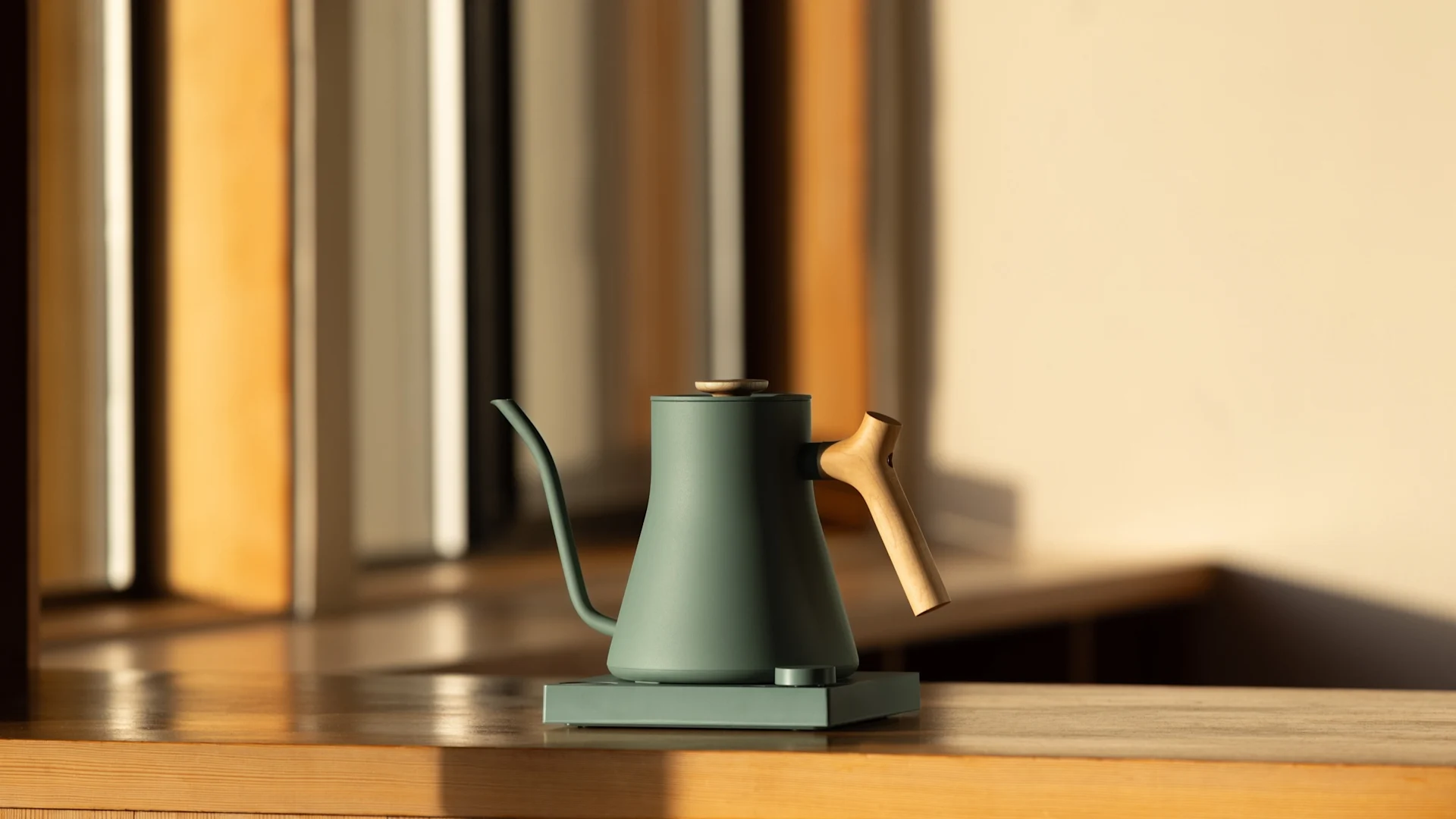 Pöydällä on Iittalan kauniissa päivänvalossa olevia laseja, lautasia ja kulhoja. 