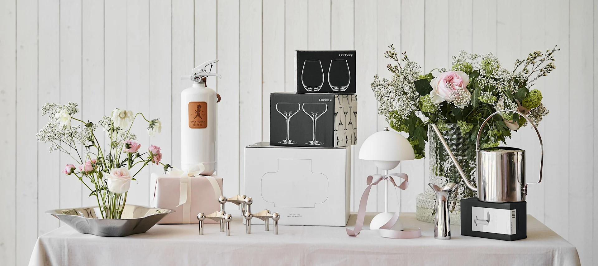 Muotoilun klassikot ovat aina hyvä häälahja morsiusparille, tässä Stoff Nagel -kynttilänjalka, Solstickan-sammutin, Alvar Aalto -kulho, Flowerpot VP9 -kannettava valaisin ja Kolonn-maljakko merkiltä Skrufs Glasbruk.