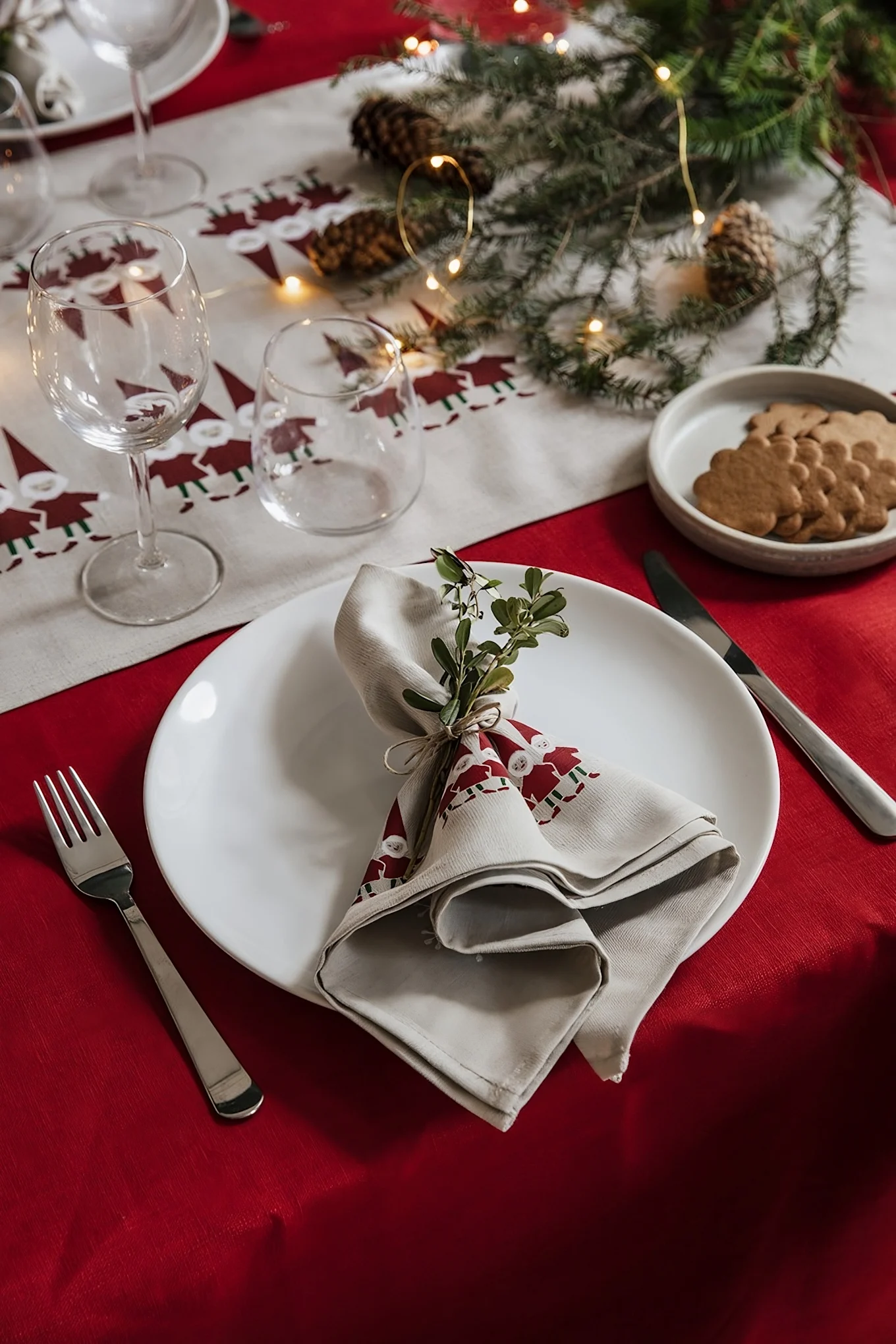 Täydelliseen skandinaaviseen jouluiseen sisustukseen kuuluvat myös sopivat tekstiilit. Tässä näet jouluisen katetun pöydän, jossa on Almedahlsin Tomtenisse-kokoelman pöytäliina ja lautasliina.