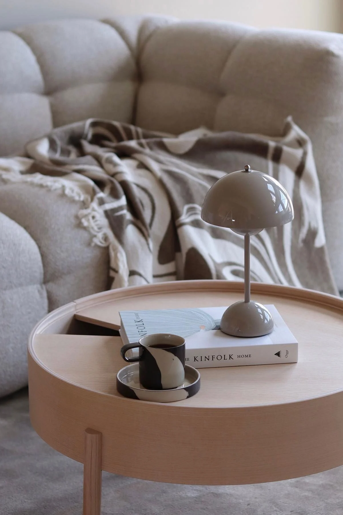 Puinen sohvapöydän koristeina ovat kirja, &Traditionin Flowerpot-pöytävalaisin ja Ferm Livingin Inlay-kuppi.