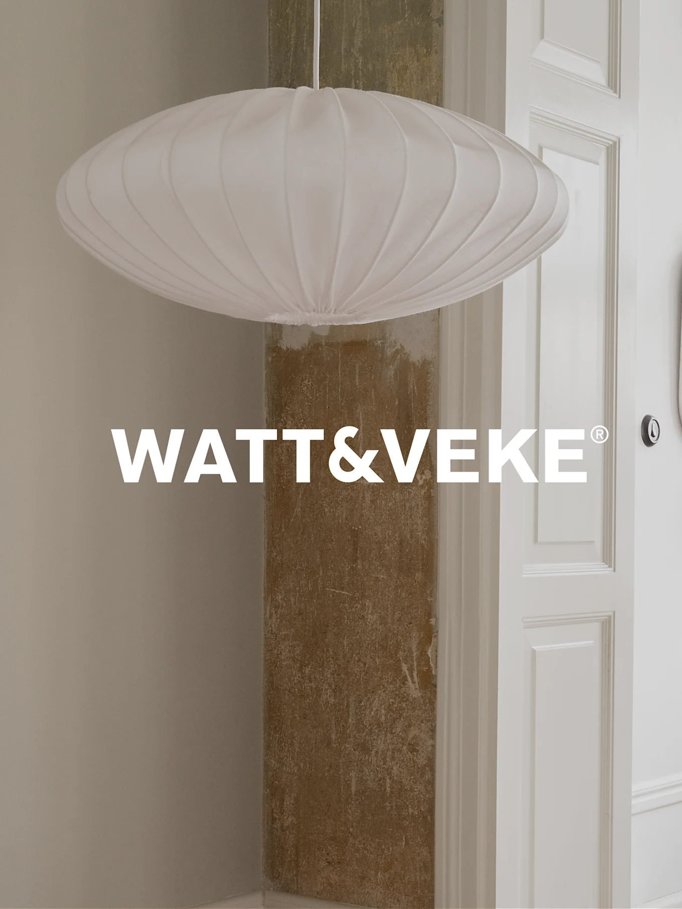 Valkoinen, laskostettu, soikea riippuvalaisin huoneessa, WATT&VEKE-logon kanssa.