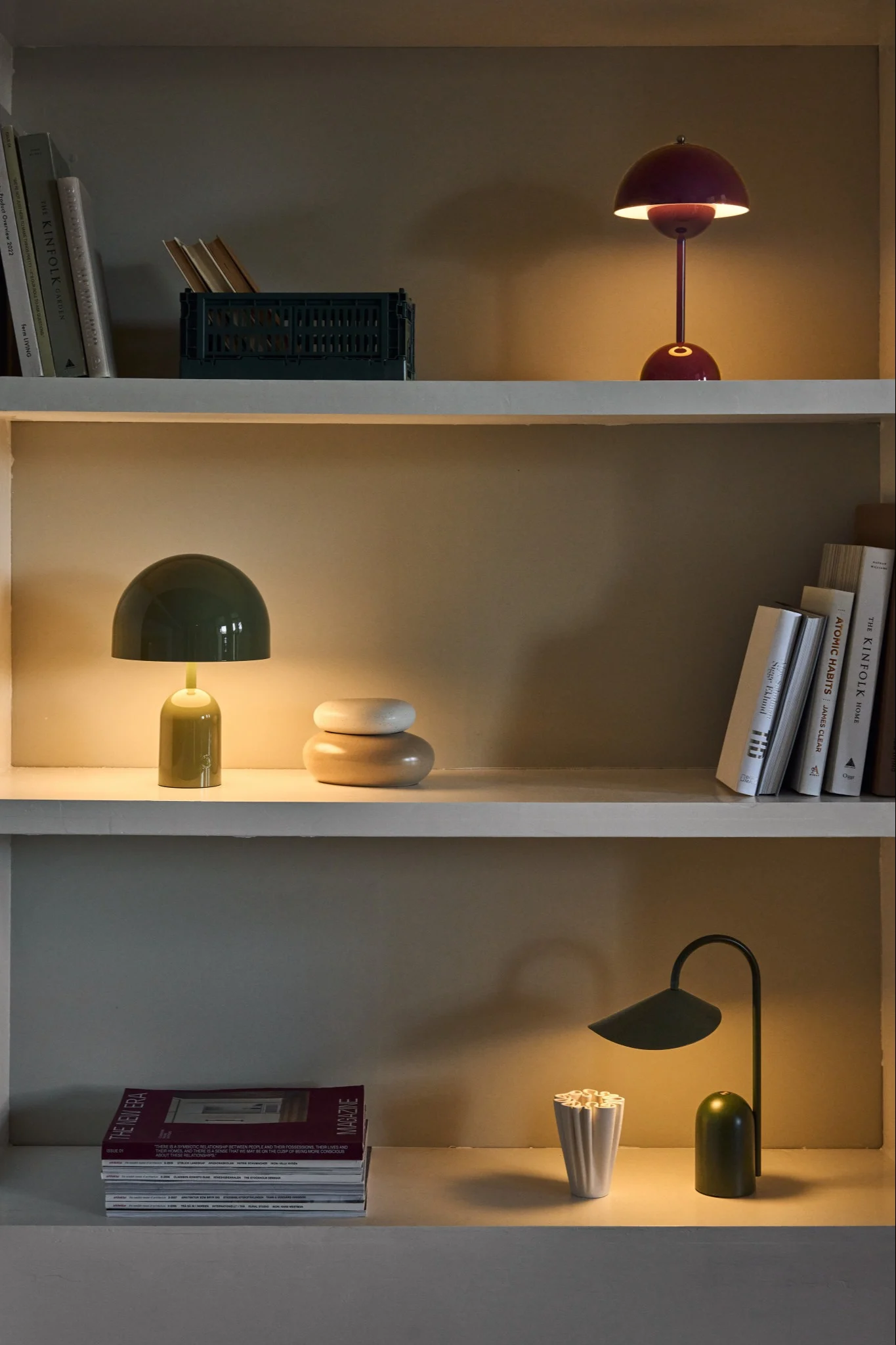 Hylly, jossa on kolme hehkuvaa, ladattavaa valaisinta Arum-, Flowerpot- ja Bell -sarjoista.