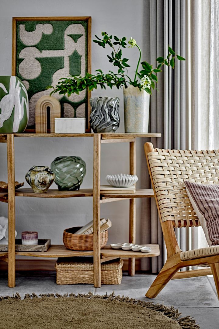 Boho-tyylisesti sisustettu olohuone, jossa on nojatuoli, koristeltu hylly ja Bloomingvillen Longton-seinäkoriste.