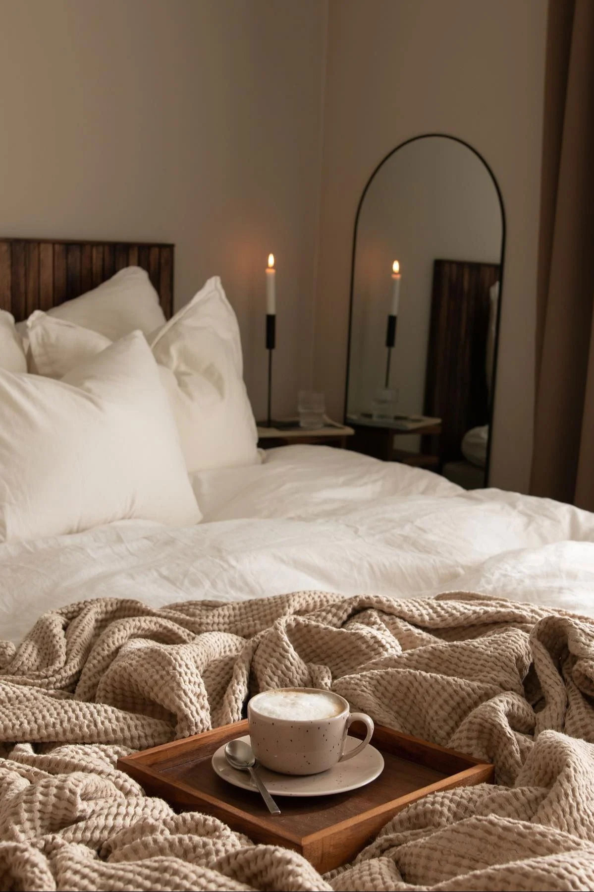 Scandi Livingin beige Freckle-muki seisoo puualustalla @joanna.aventon makuuhuoneen kodikkaassa sängyssä.