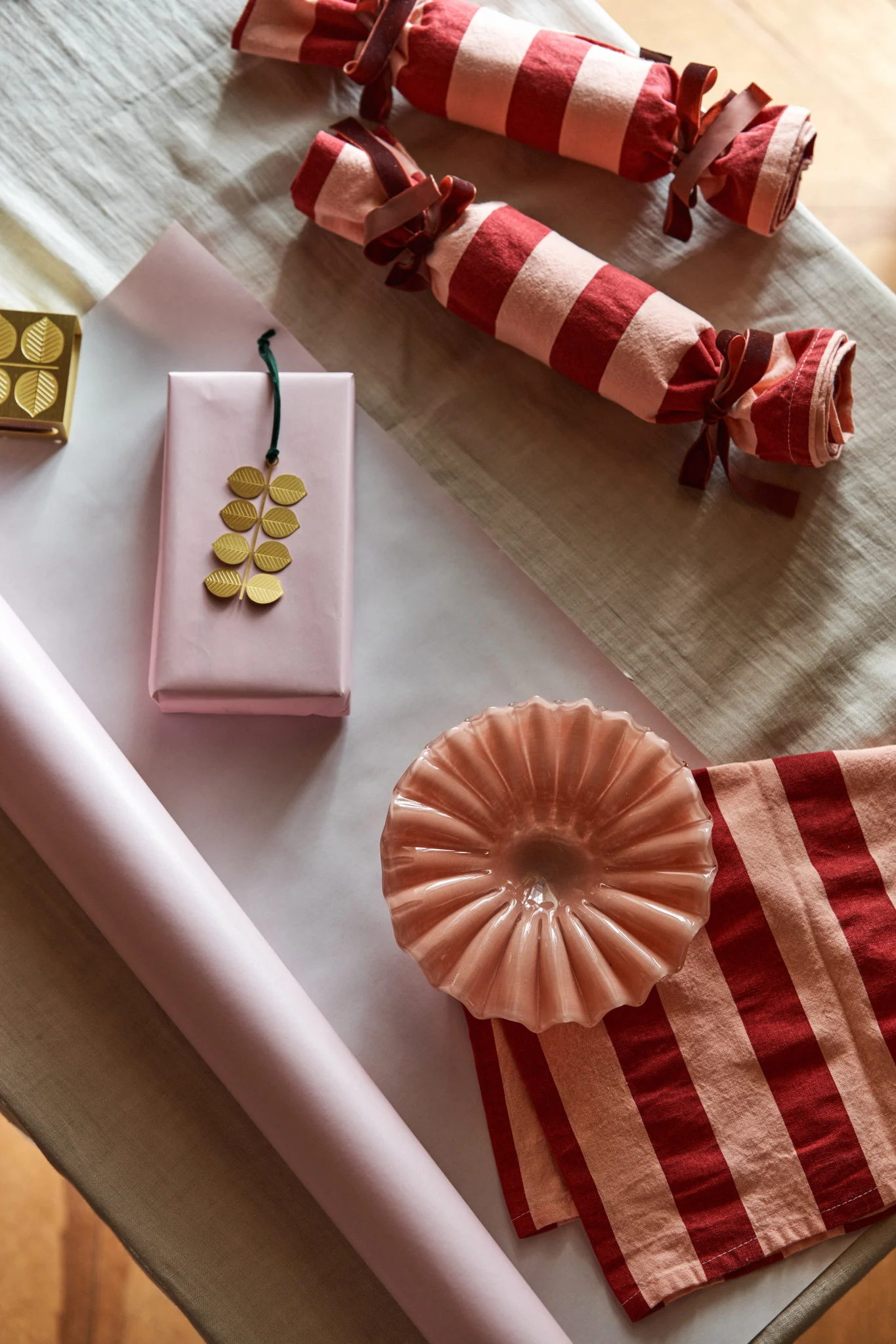 Täällä odottaa vaaleanpunainen kulho Byonilta ja kultainen riipus Plutolta, jotka kääritään kauniisti raidallisiin keittiöpyyhkeisiin ja vaaleanpunaiseen paperiin – luova tapa juhlia ensimmäistä adventtia.