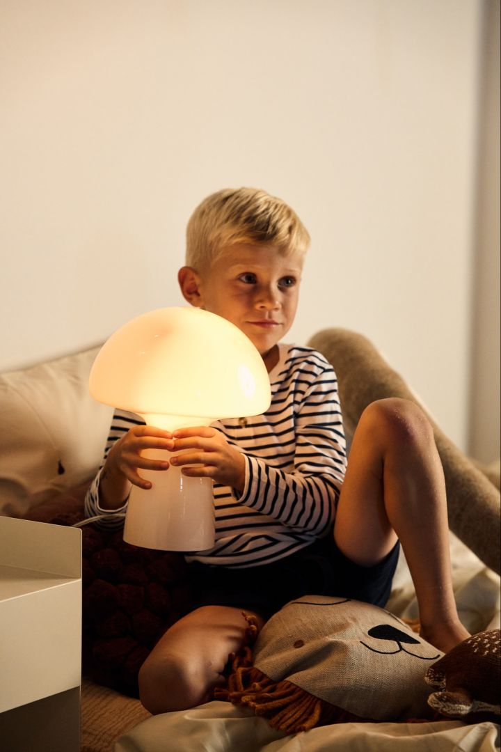 Valitse oikea hehkulamppu - nuorella pojalla on kädessään hehkuva sienen muotoinen lamppu.