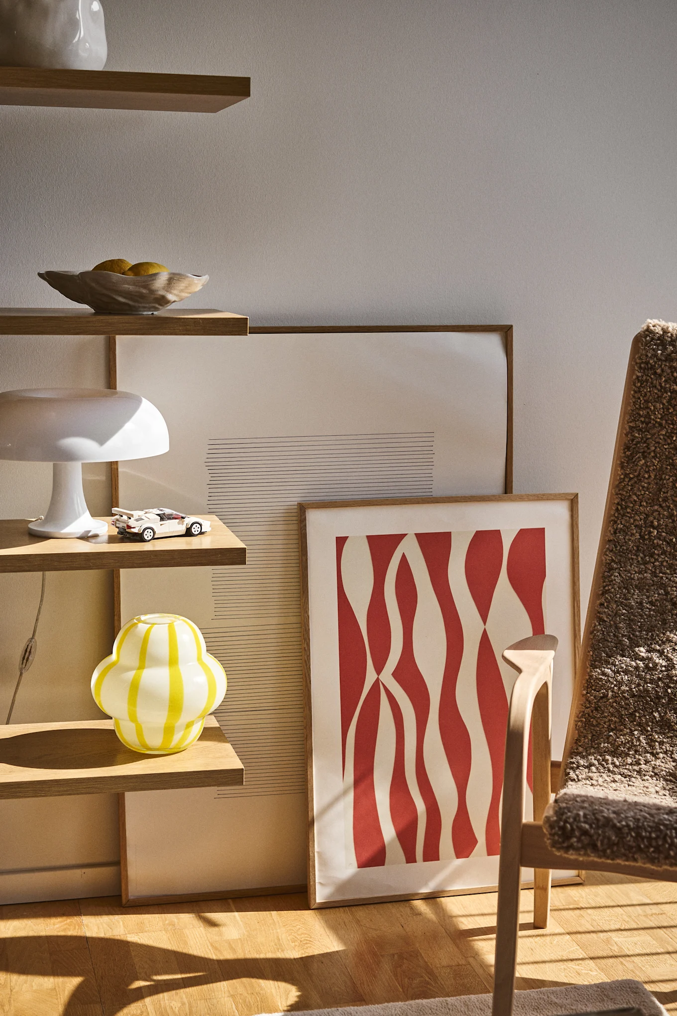 Byonin Curlie-maljakossa on pyöreä, sipulimainen muotoilu keltaisesta ja valkoisesta raidallisesta lasista. Tässä sijoitettu avoimeen kirjahyllyyn yhdessä Shell-maljan, lamppujen ja maalausten kanssa.