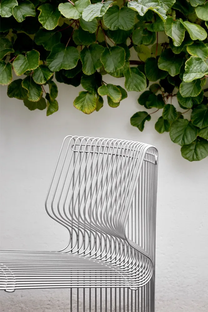 Osa modulaarisesta Pantonova-sohvasta on ulkona, köynnöskasvien kehystämänä.