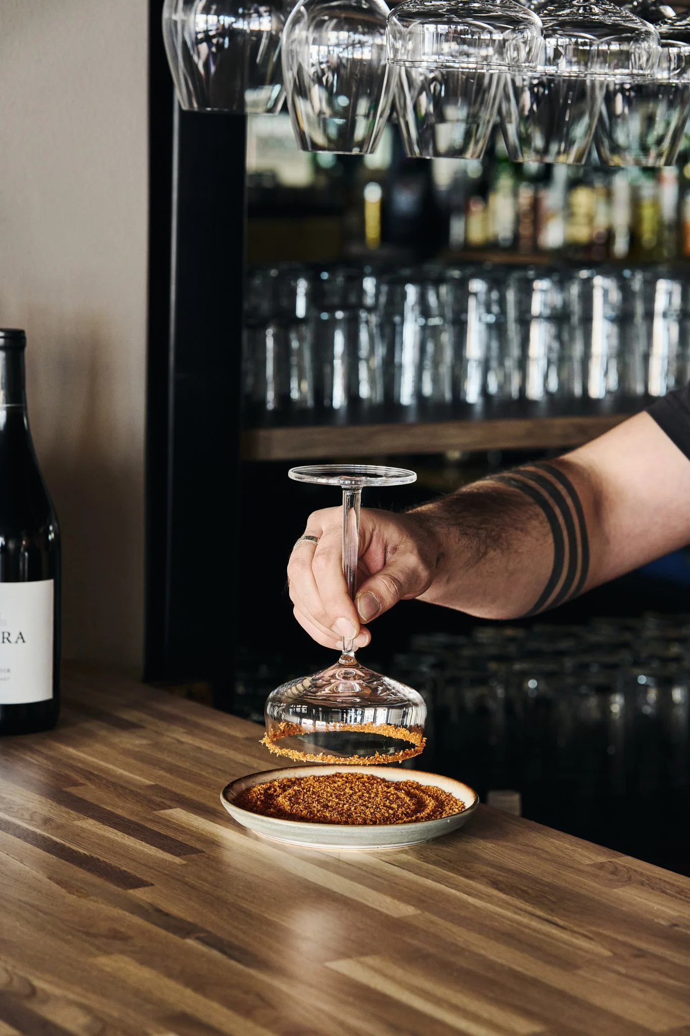 Käsi kastaa margarita-cocktaillasin reunan suolaseokseen, jotta juomaan saadaan lisää makua.