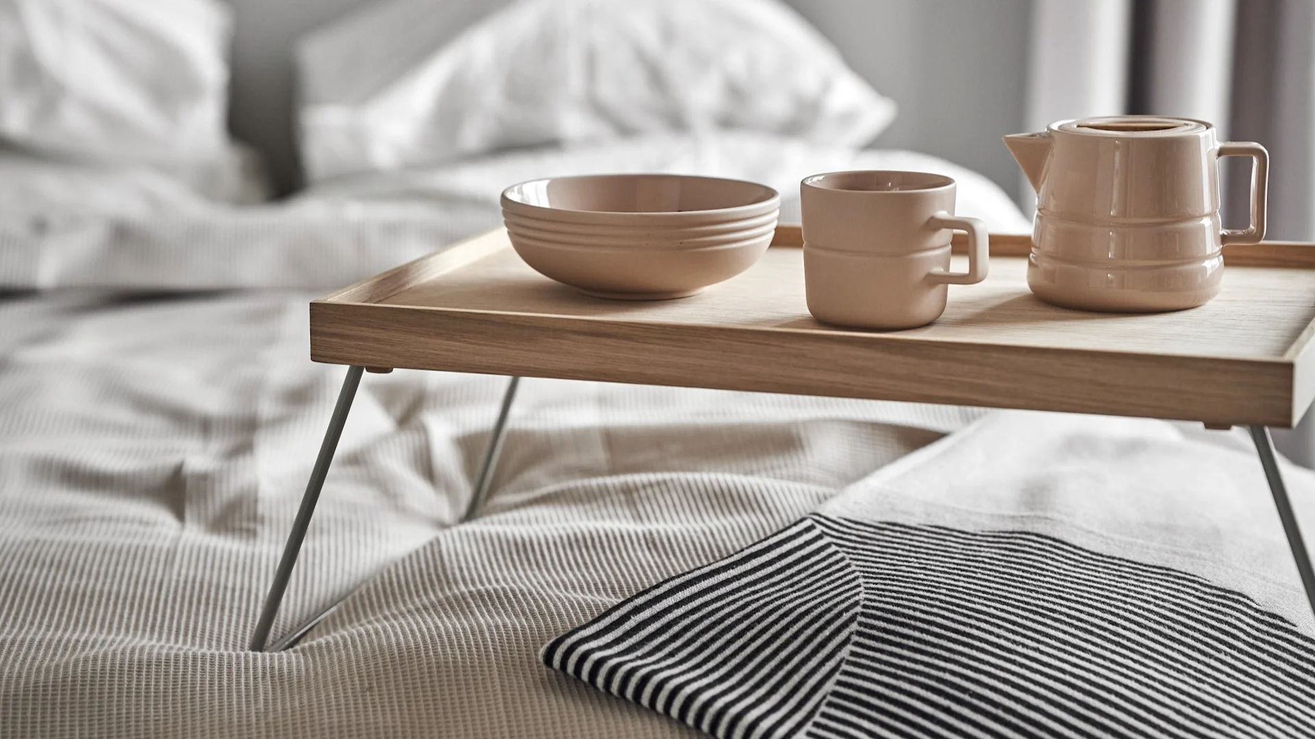 Lagom tarkoittaa myös rentouttavaa päivän alkua. Tässä kuvassa NJRD:n Lines-sarjan kuppi, kannu ja kulho ovat aamiaistarjottimella sängyssä.