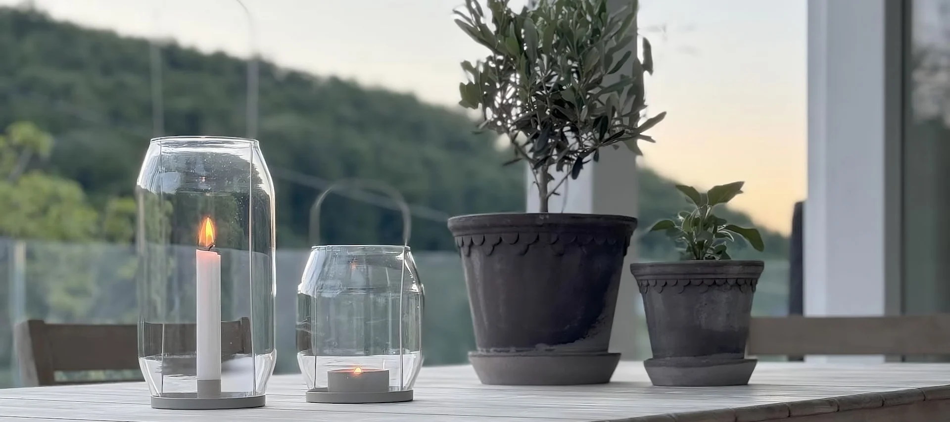 Kaksi Bergs Potterin Copemhagen kukkaruukkua seisoo pöydällä kahden Ernst-lyhdyn vieressä @zuhauseligin terassilla.