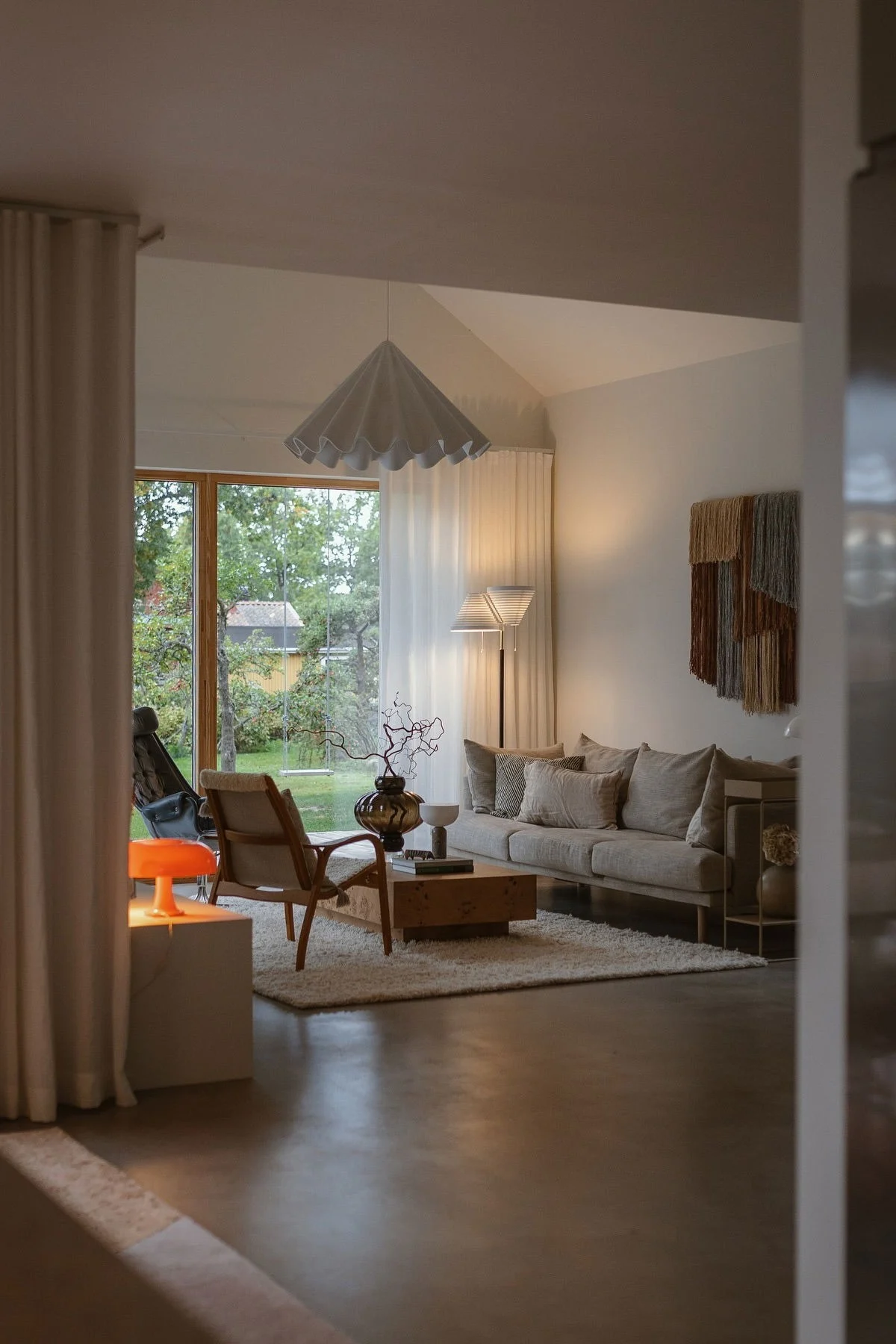 Applauddenin olohuoneessa loistaa oranssi lamppu, joka heijastaa vuoden 2026 sisustustrendejä.